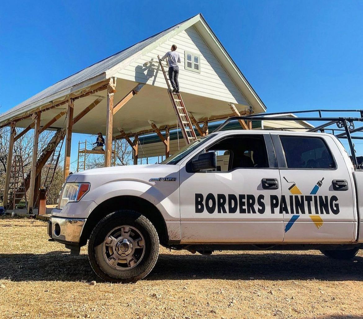 A borders painting truck is parked in front of a house