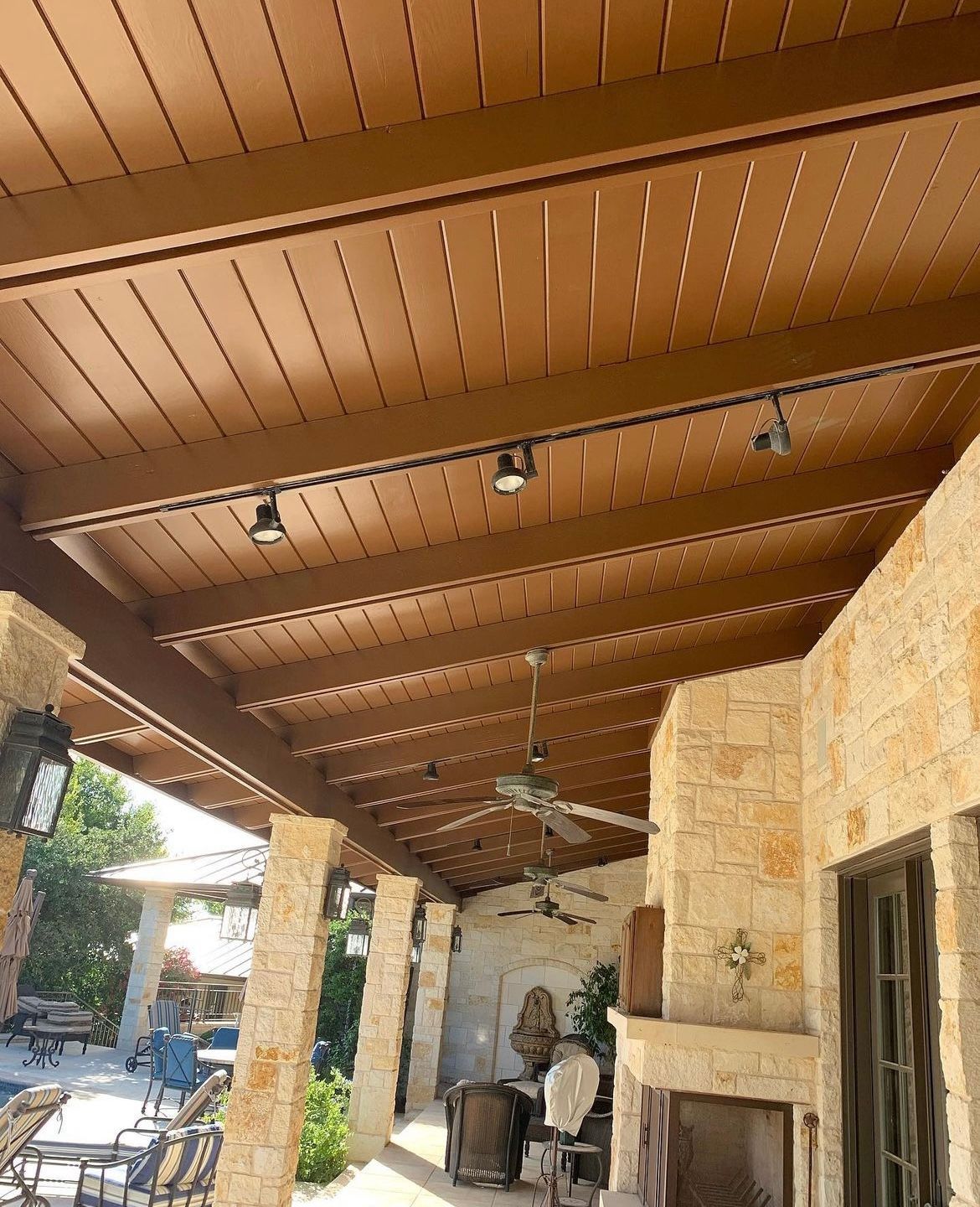 A patio with a wooden ceiling and a fireplace