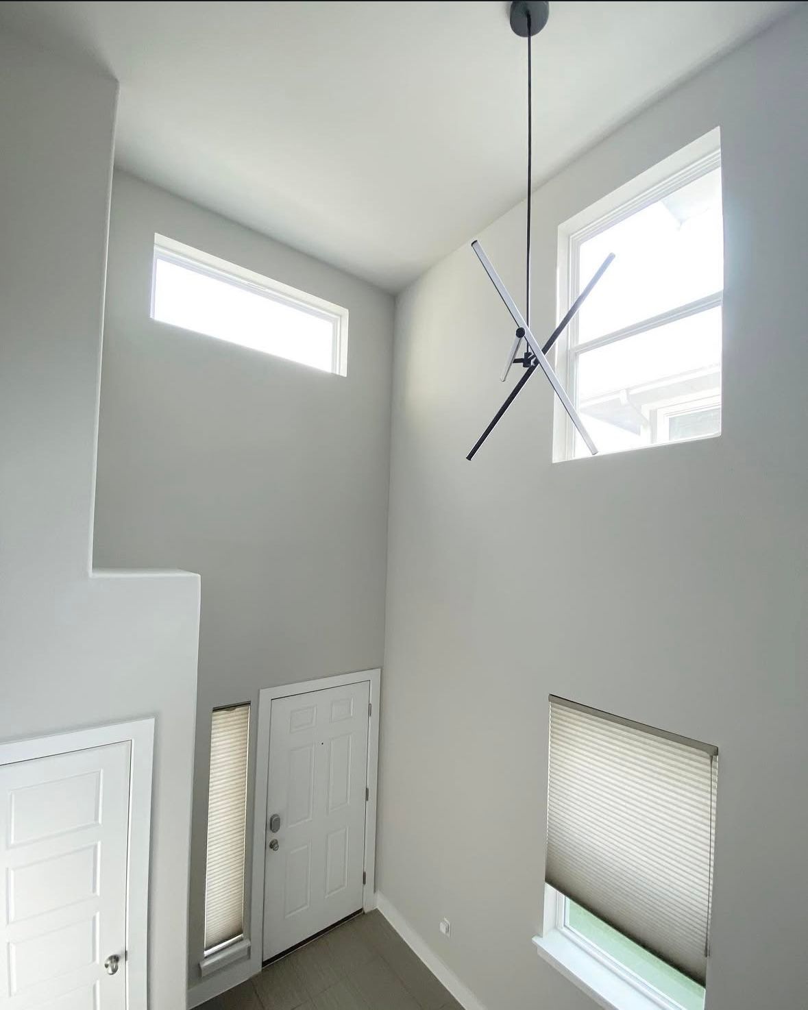 An empty room with a ceiling fan hanging from the ceiling
