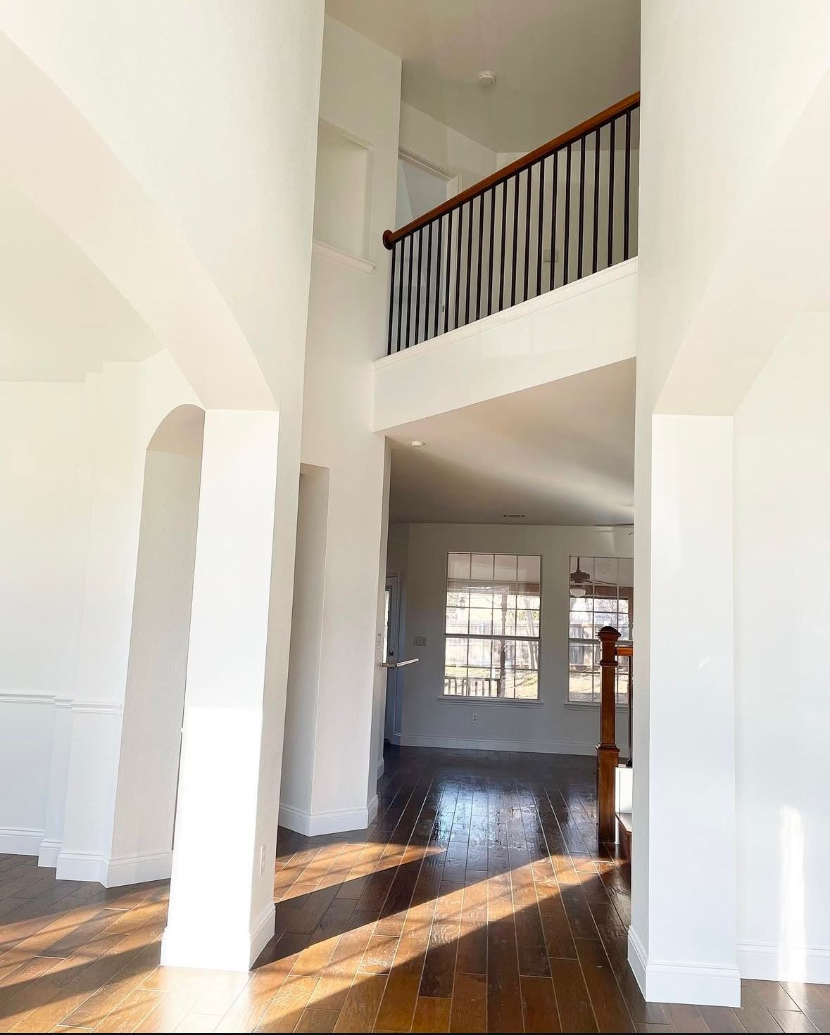 A large empty room with a balcony and stairs