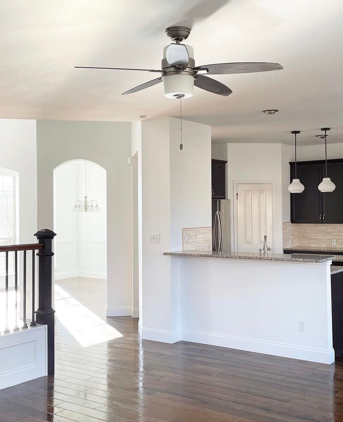 An empty kitchen with a ceiling fan above the counter