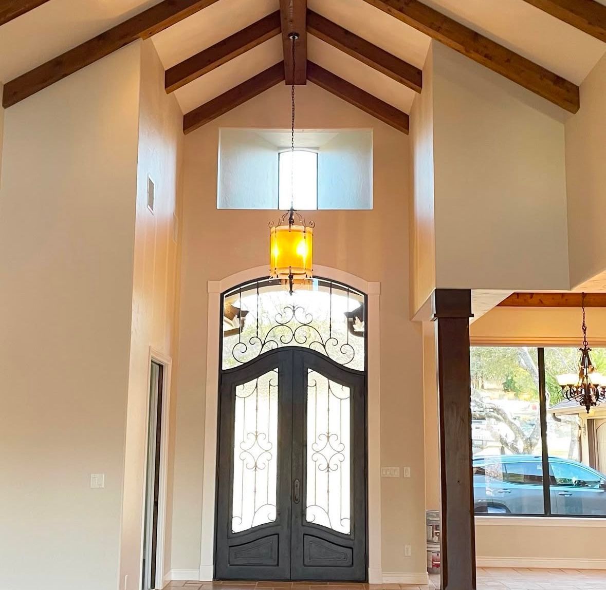 A house with a vaulted ceiling and a black door