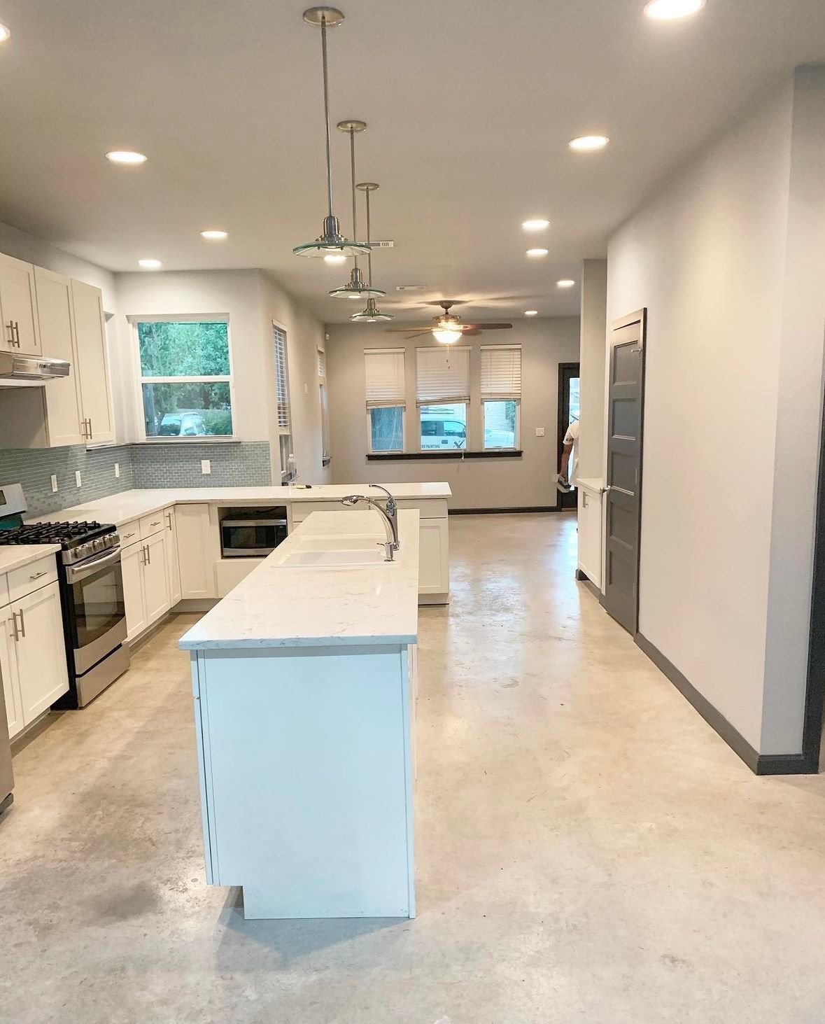 An empty kitchen with white cabinets and a large island