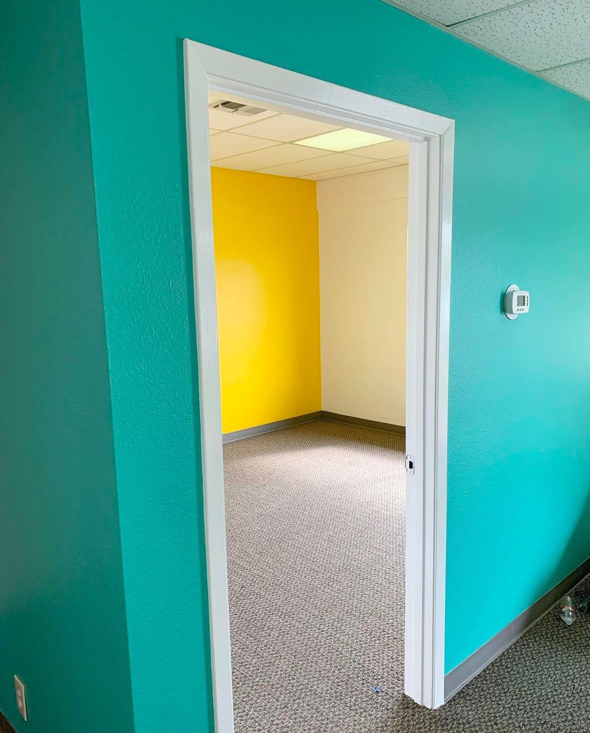 A doorway leading into a room with blue walls and yellow walls.