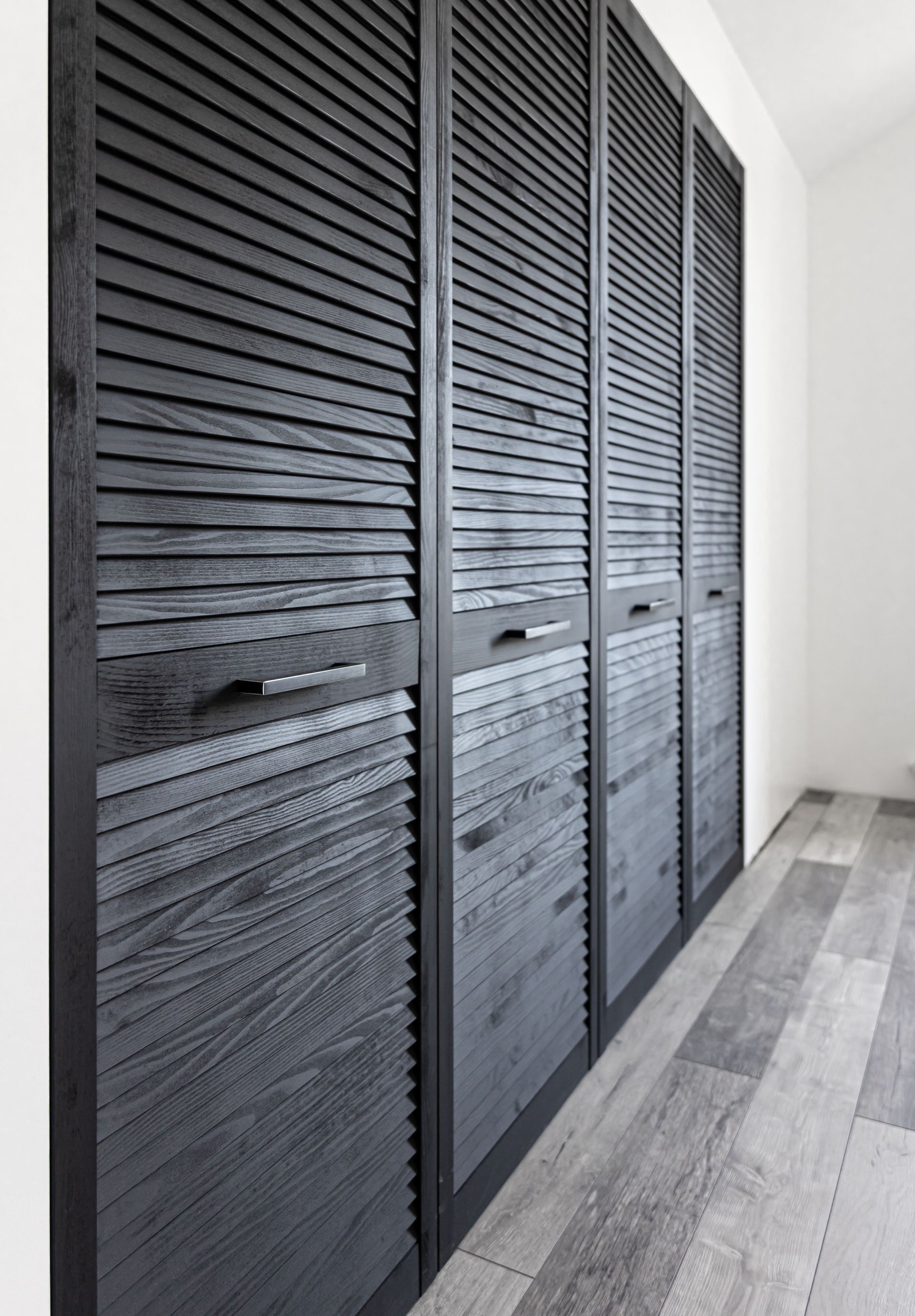 A row of black shutters on a wall in a room.