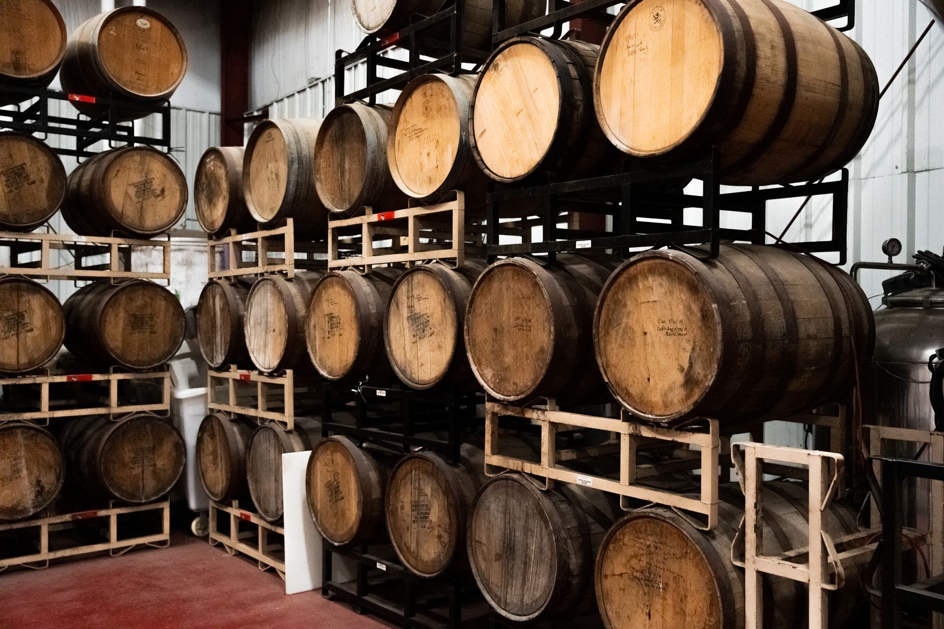 a warehouse filled with lots of wooden barrels stacked on top of each other at Thomas Creek Brewery