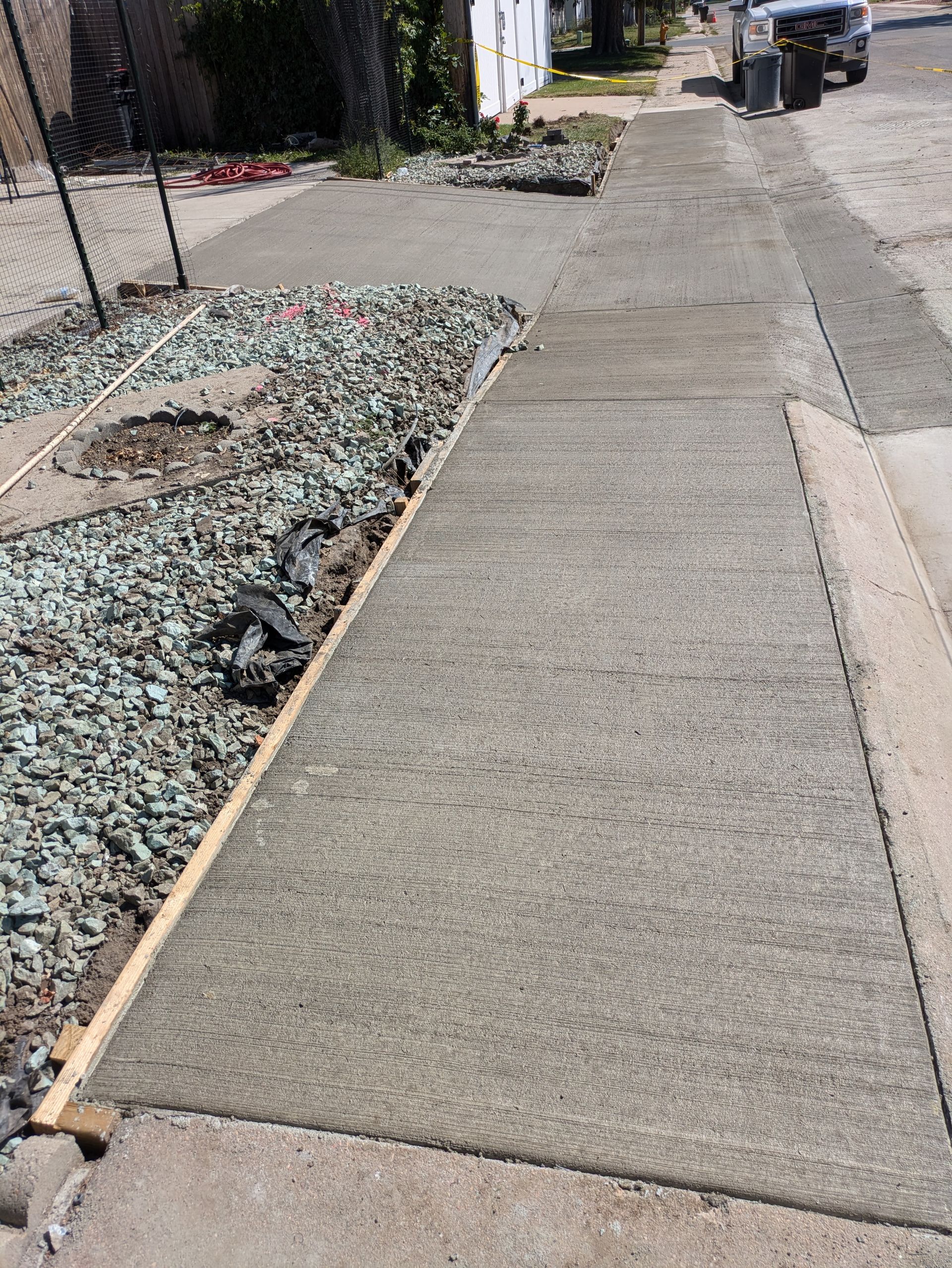 A concrete sidewalk is being built next to a gravel area.