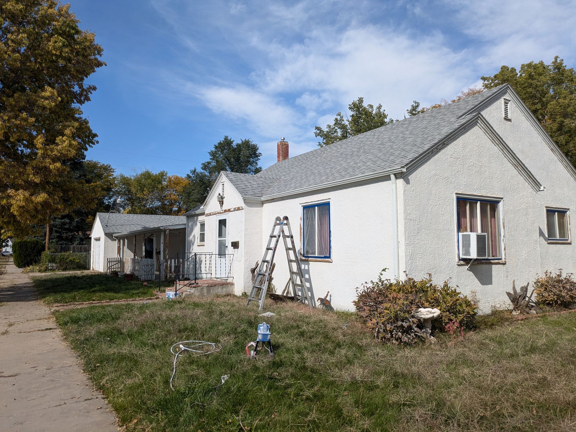 A white house with a ladder in front of it