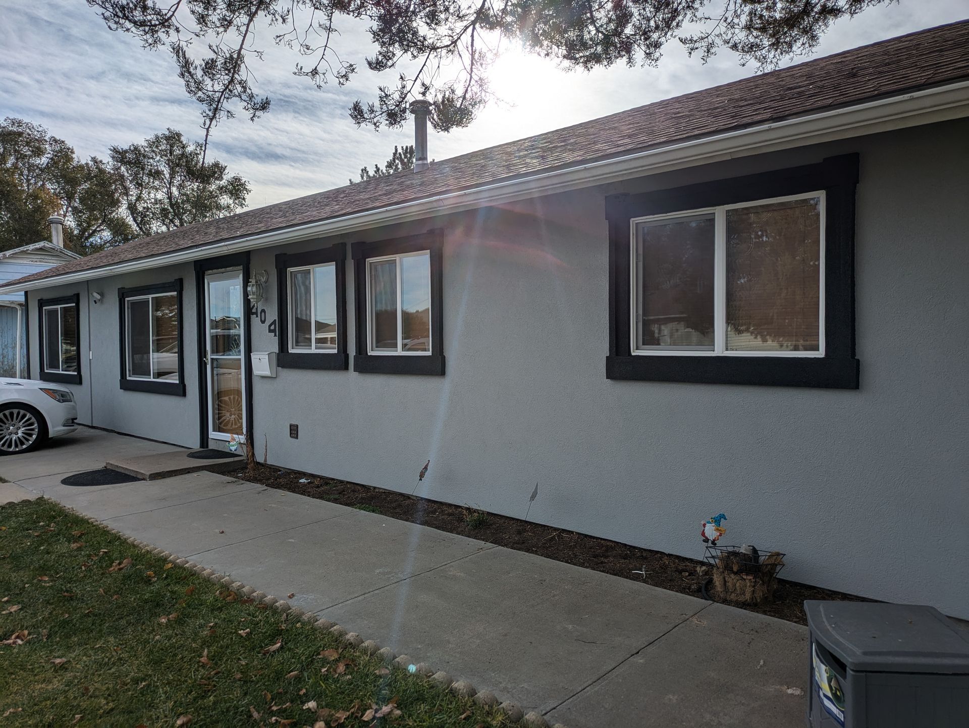 A house with a lot of windows and a car parked in front of it.