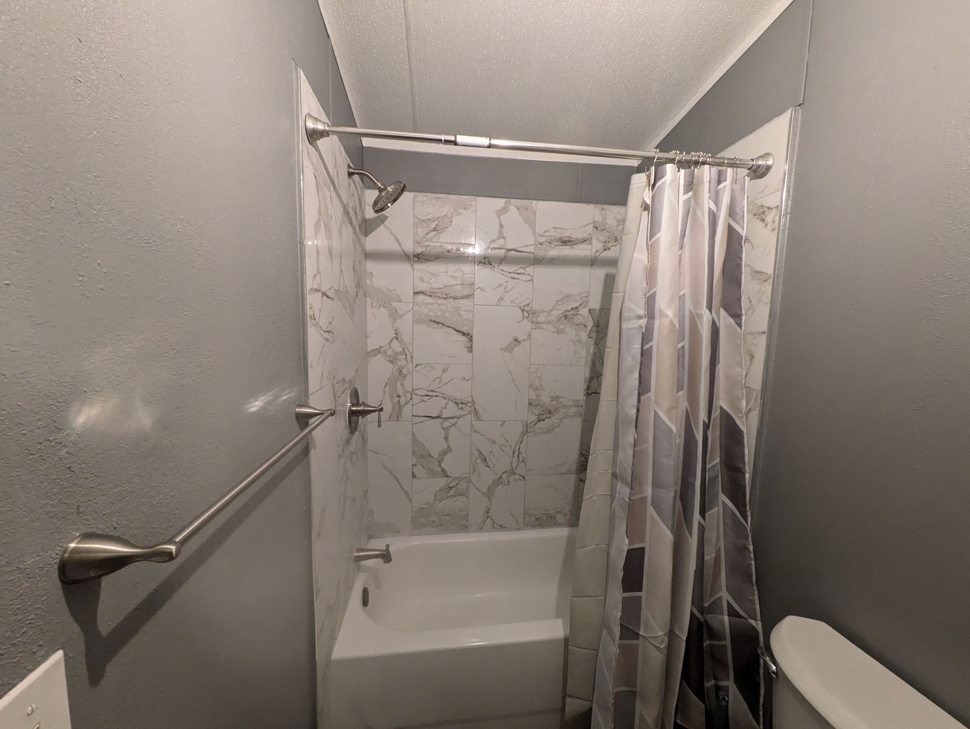 A bathroom with a tub , shower and toilet.