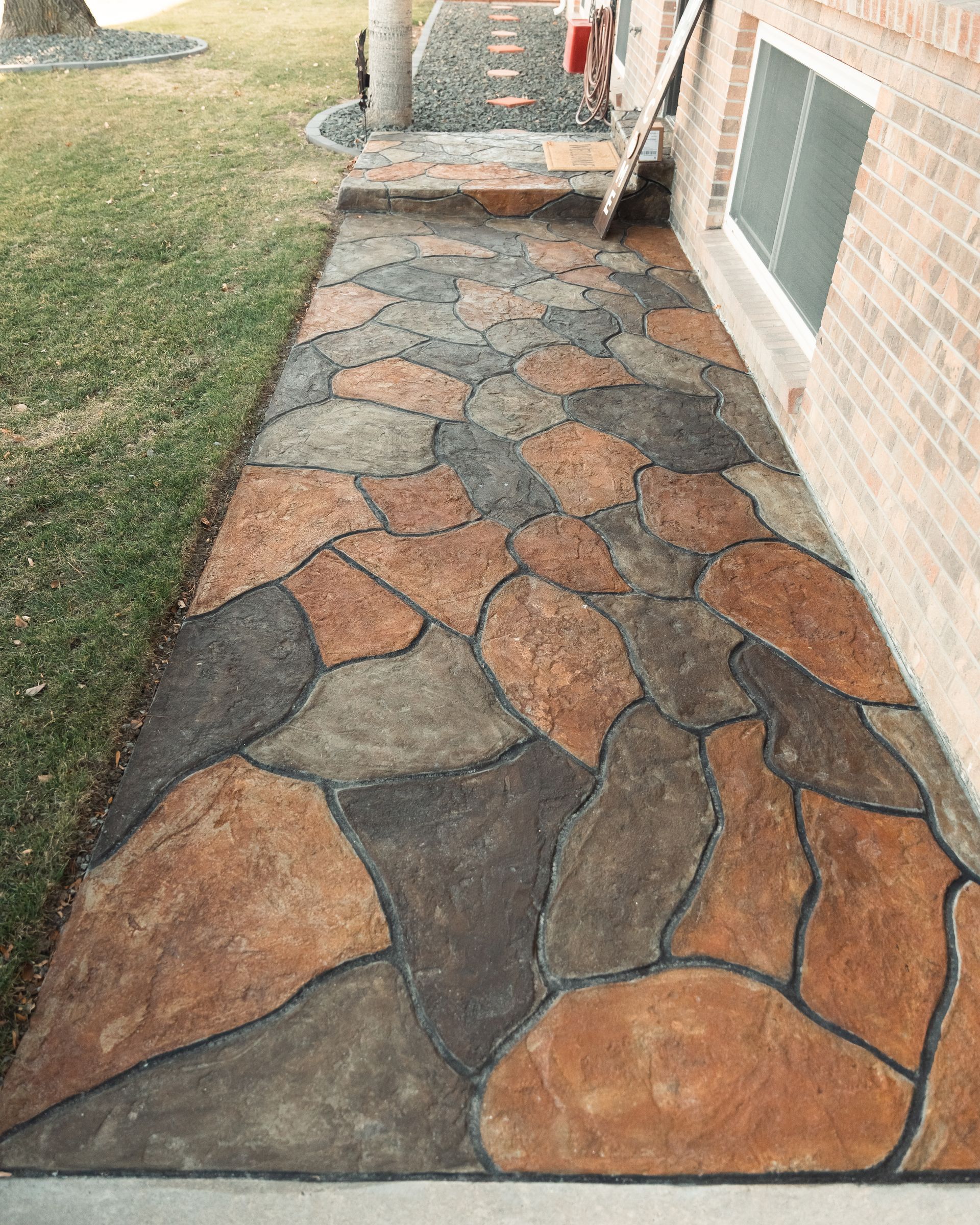 A stone walkway is leading to a brick building.