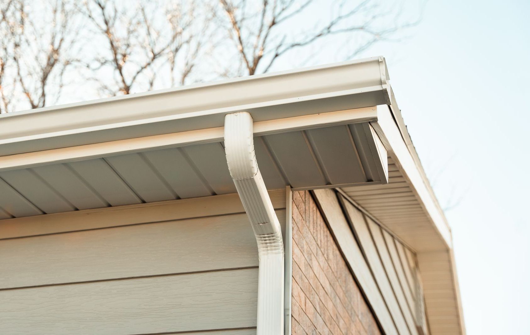 A close up of a gutter on the side of a house.