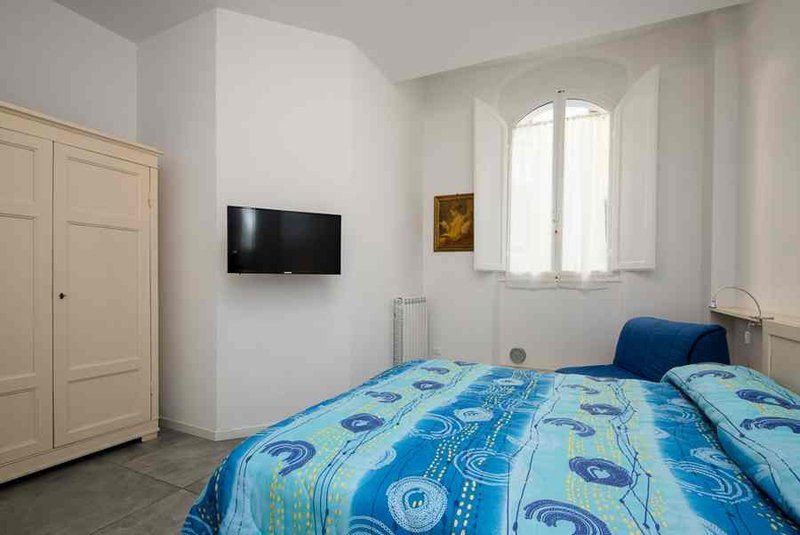 Zona notte con letto matrimoniale e televisore a muro