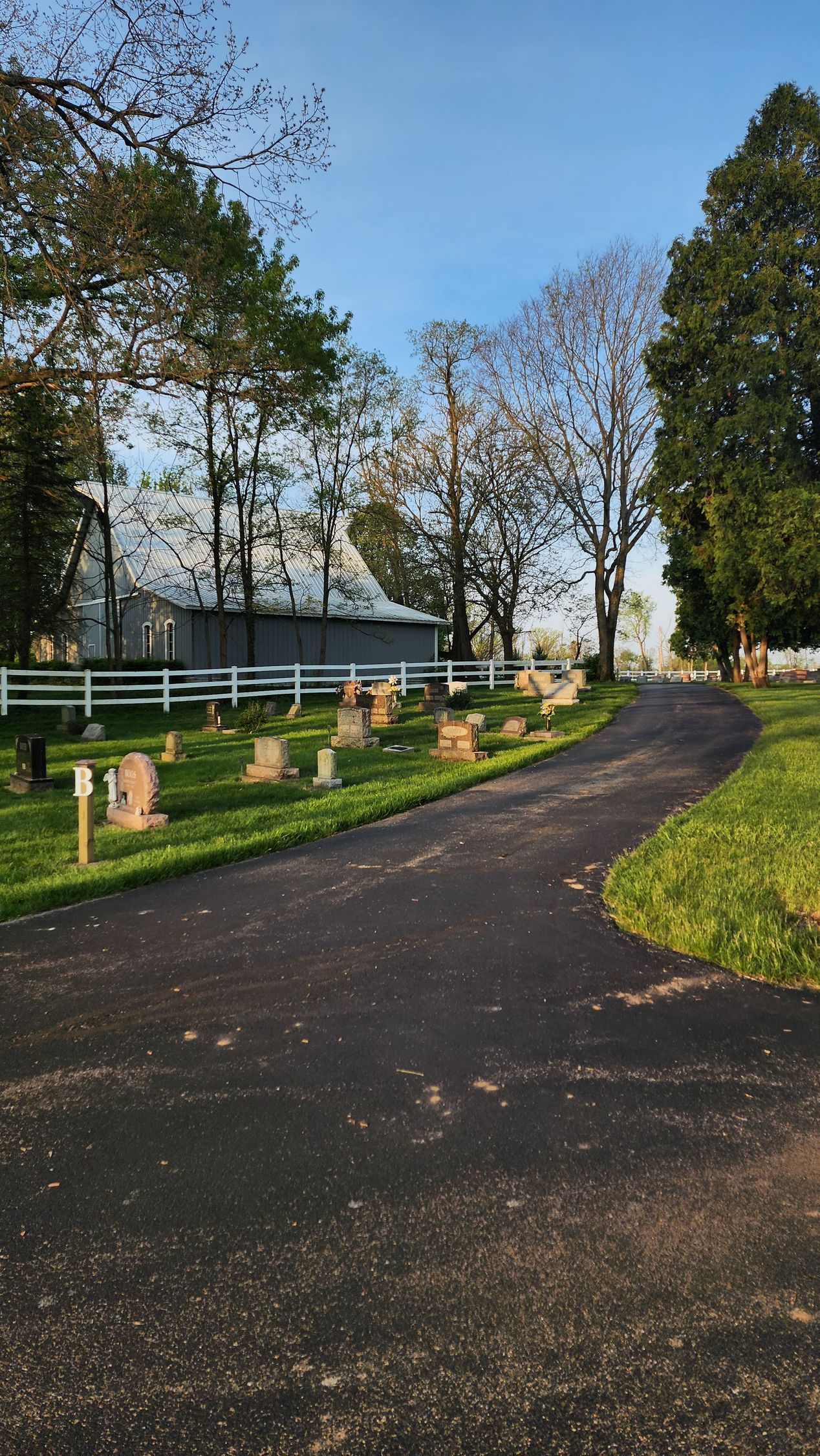 A road going through a cemetery with trees on both sides.