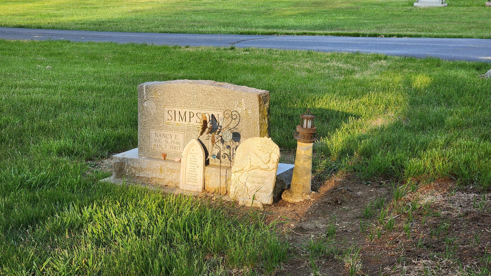 A grave in a cemetery with a lighthouse.
