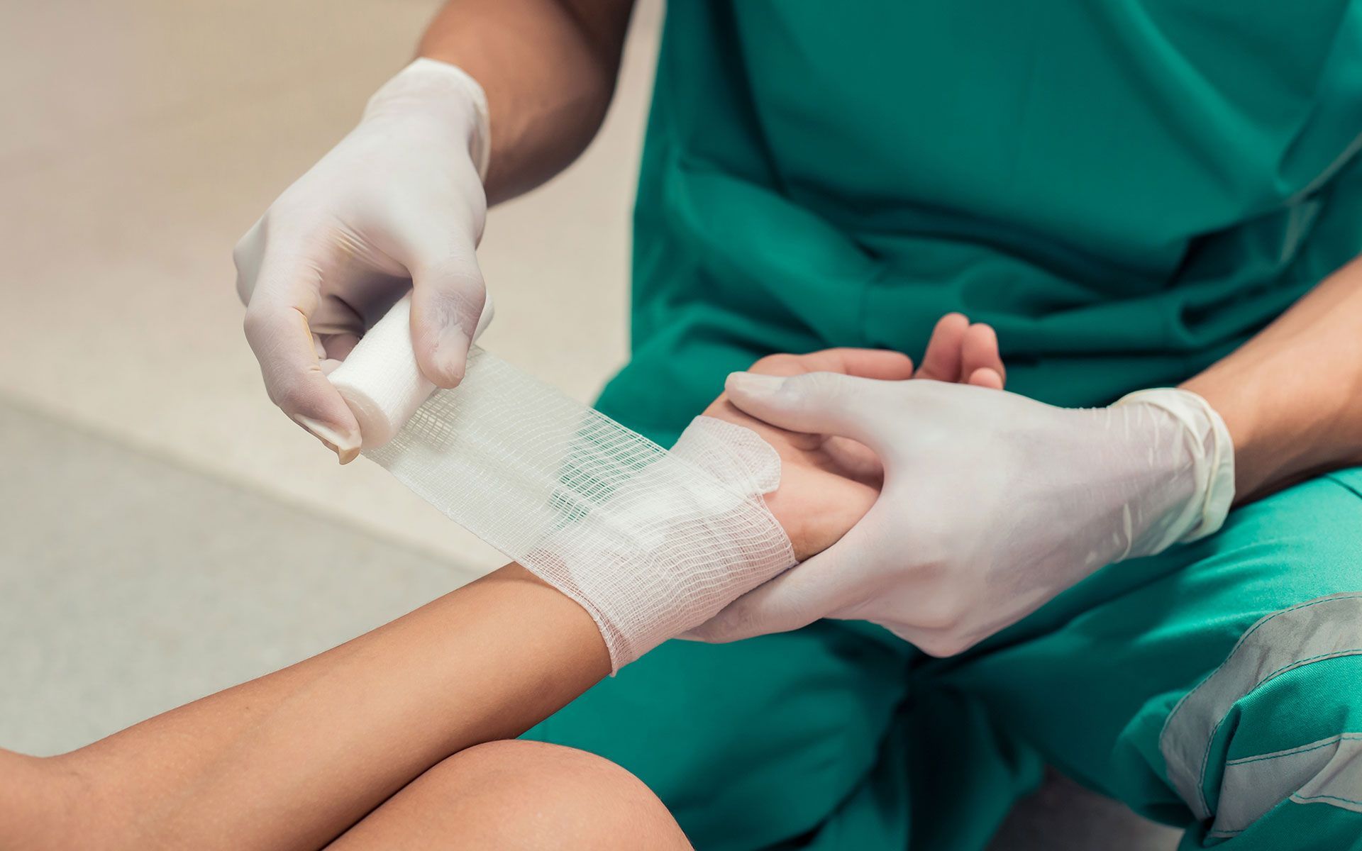 A person is getting a bandage on their wrist.
