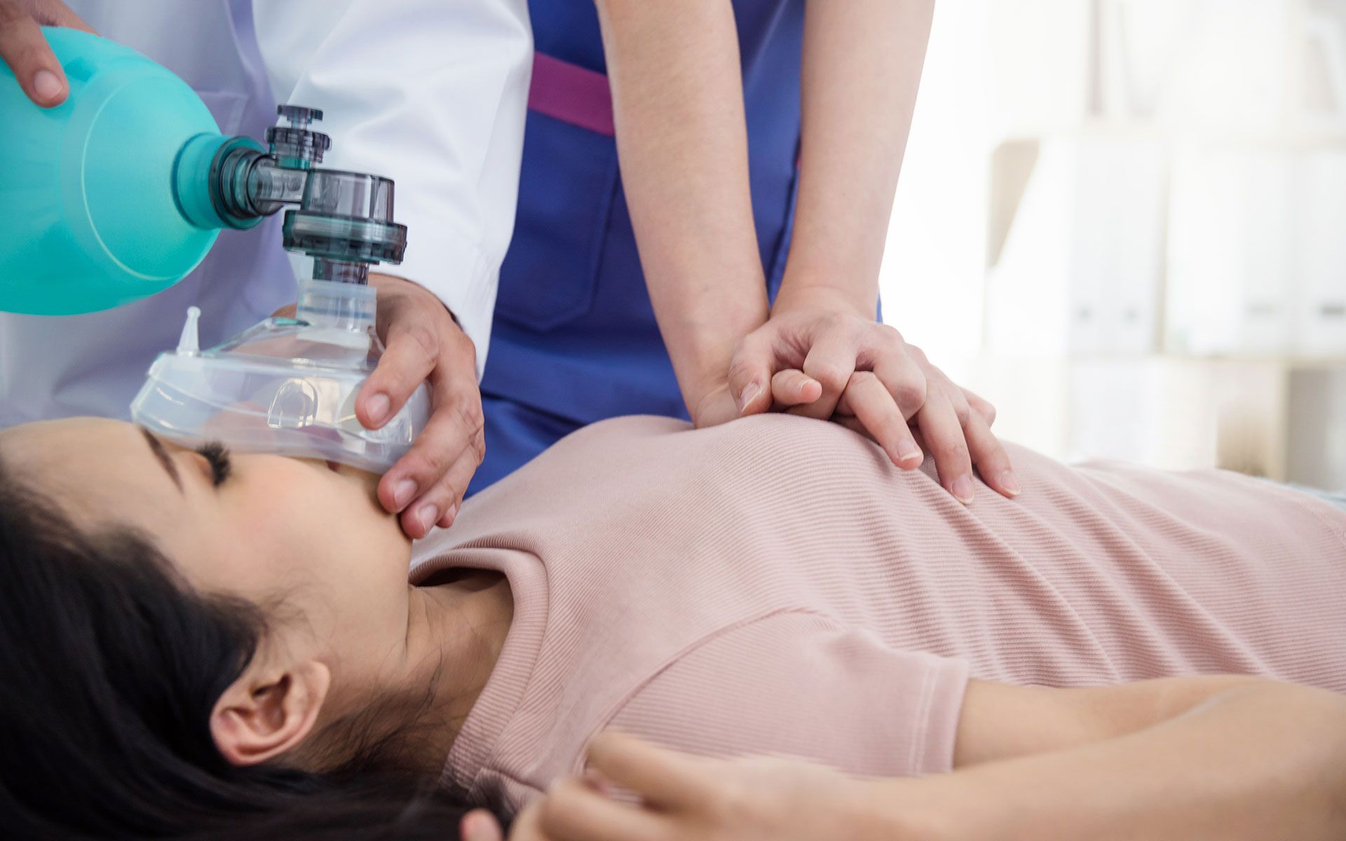 A woman is laying on the floor with an oxygen mask on her face.