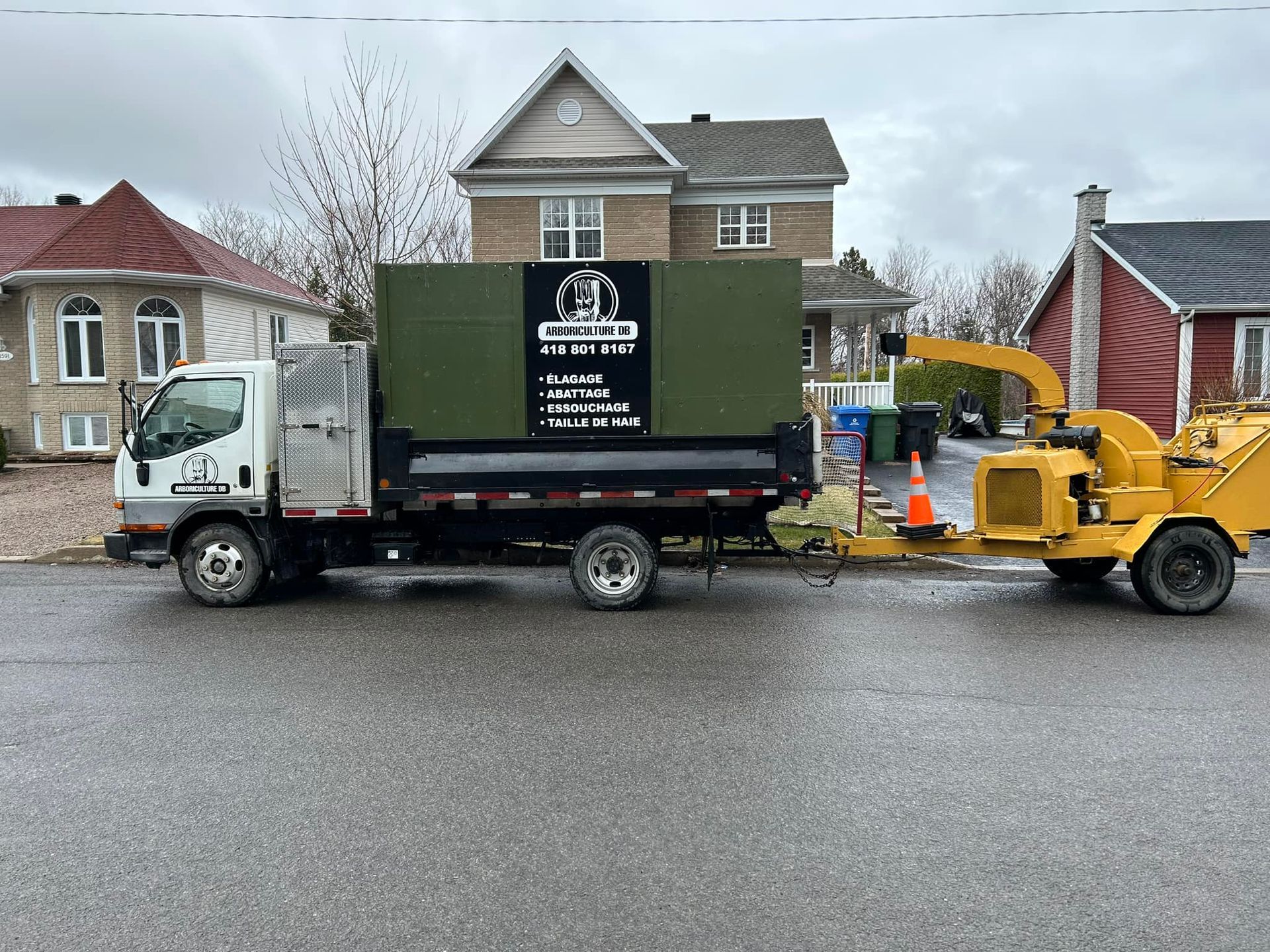 Un camion avec une remorque attachée est garé devant une maison.