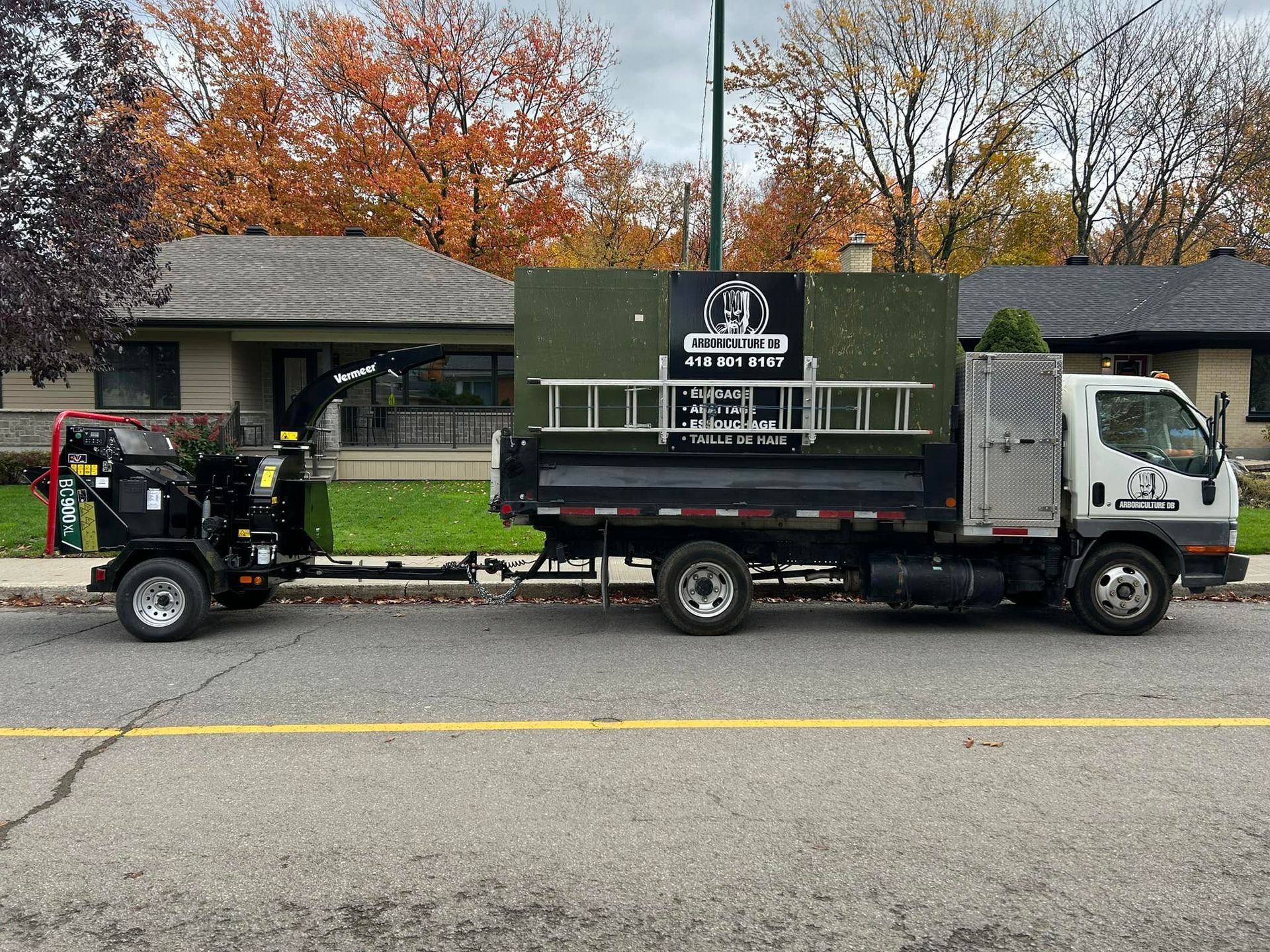 Un camion à benne basculante avec une remorque attachée est garé sur le bord de la route.