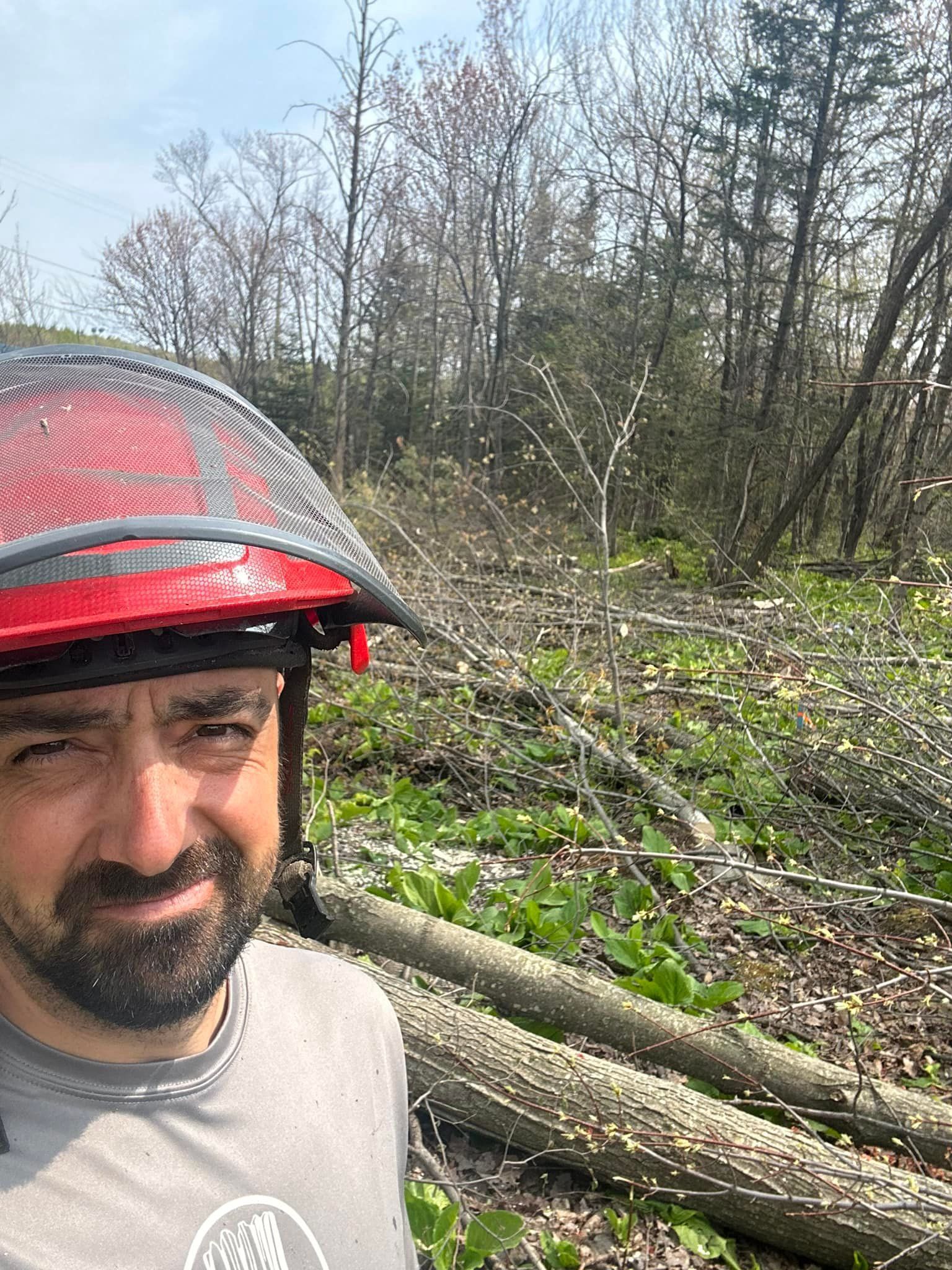 Un homme portant un casque rouge se tient debout dans une forêt.