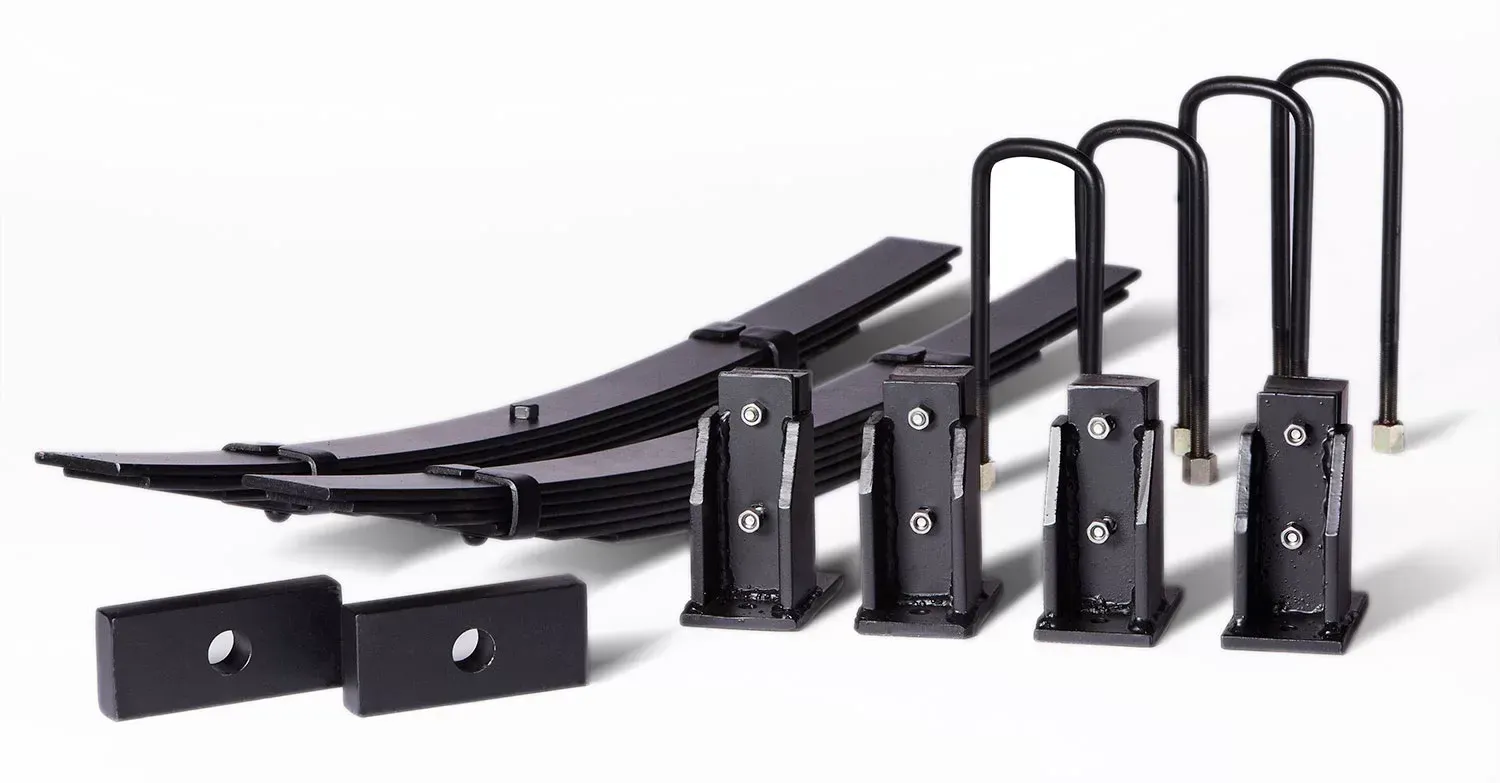 Componenti del kit di sollevamento delle sospensioni del camion neri su sfondo bianco: balestre, staffe, bulloni a U.