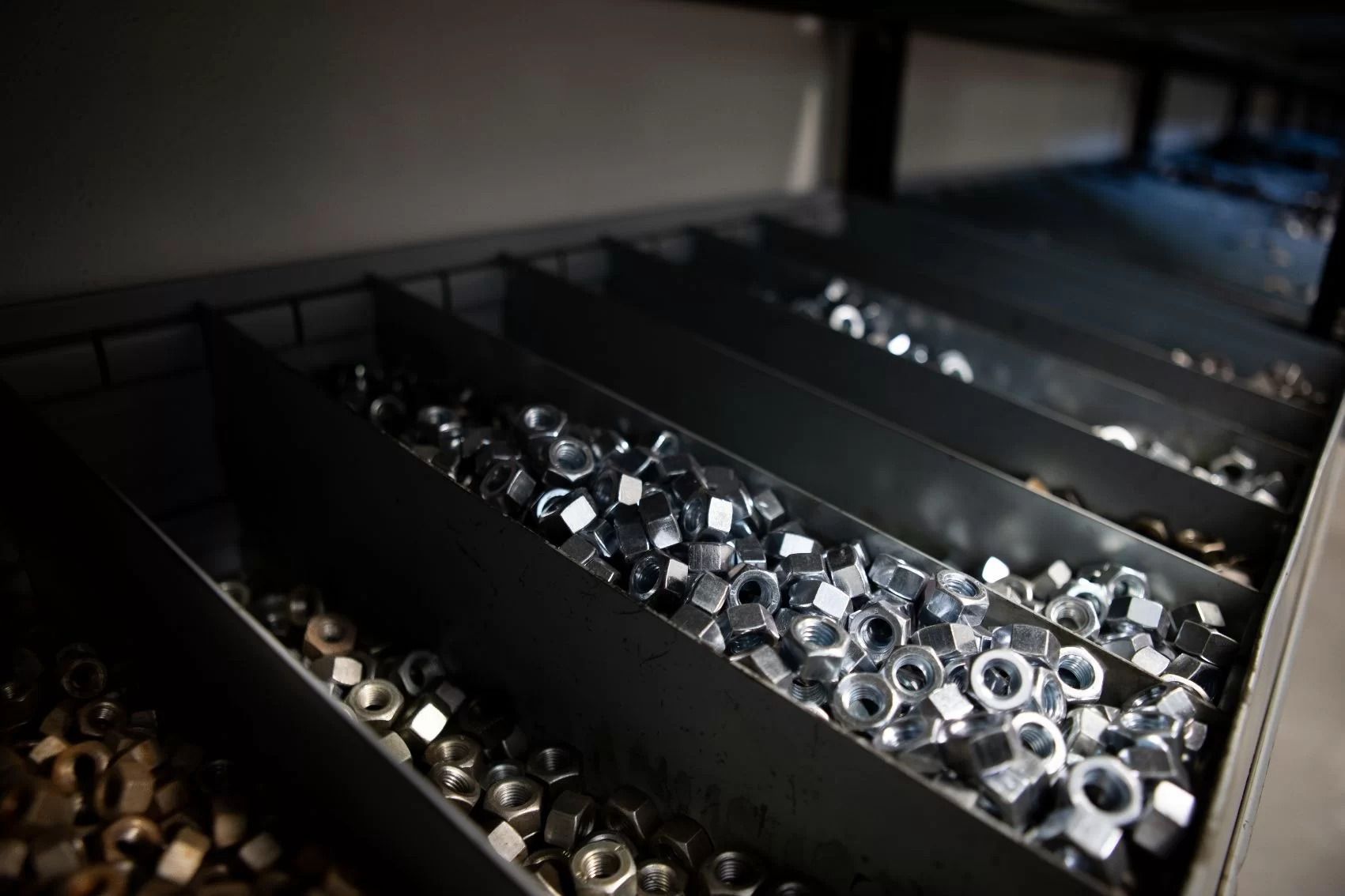 Dadi metallici in vassoi divisi all'interno di un armadietto.