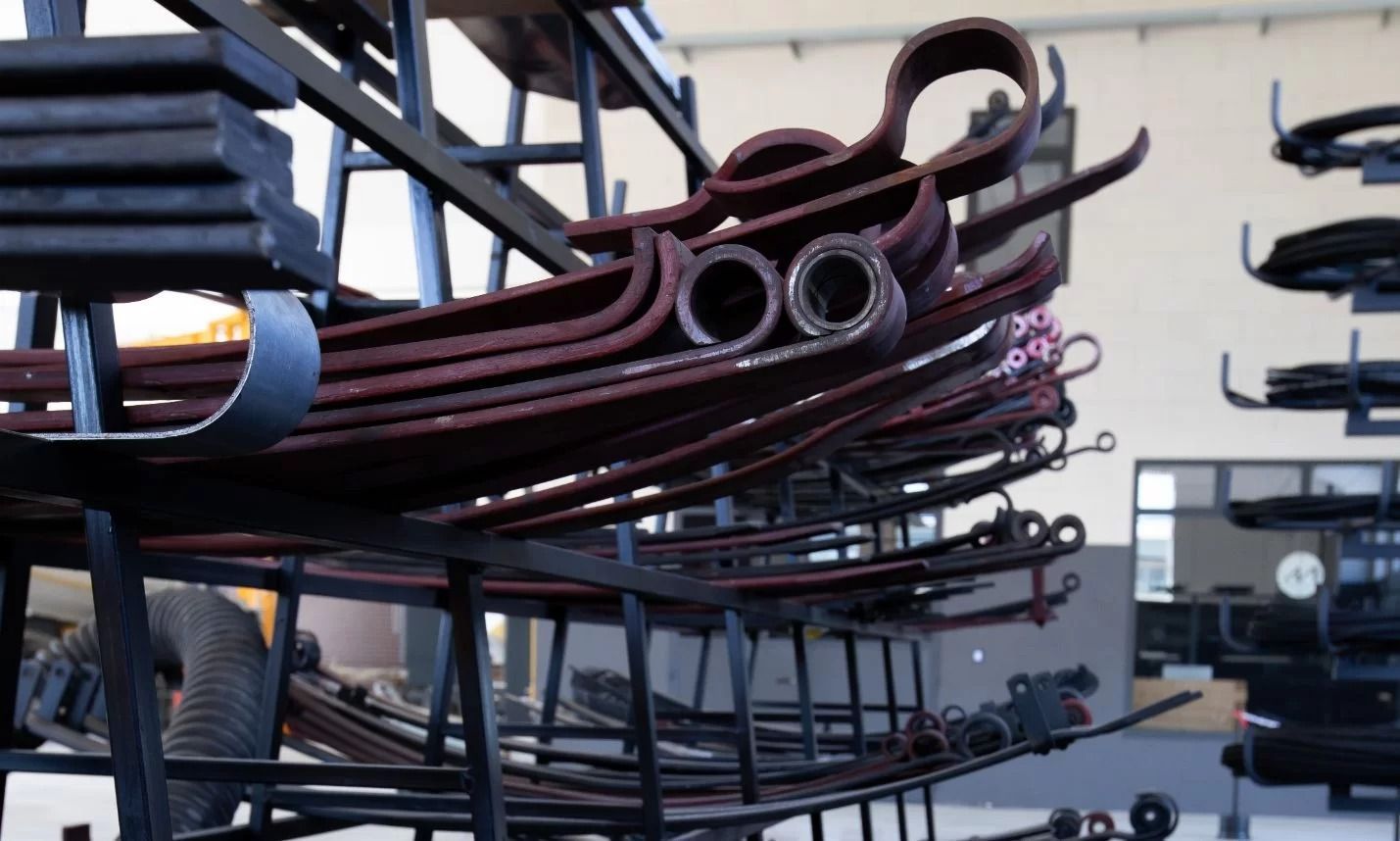 Balestre, di colore rosso-marrone, impilate su supporti metallici in una configurazione di fabbrica.