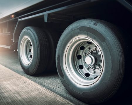 A close up of a truck 's tires on a road.