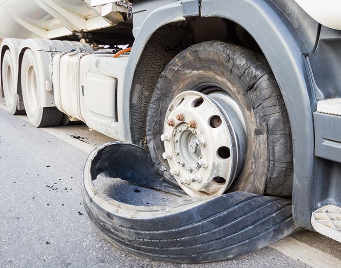 A truck with a flat tire on the side of it.