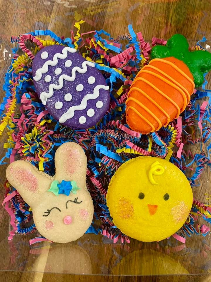 Easter macarons: purple egg, orange carrot, white bunny, yellow chick, on colorful paper.