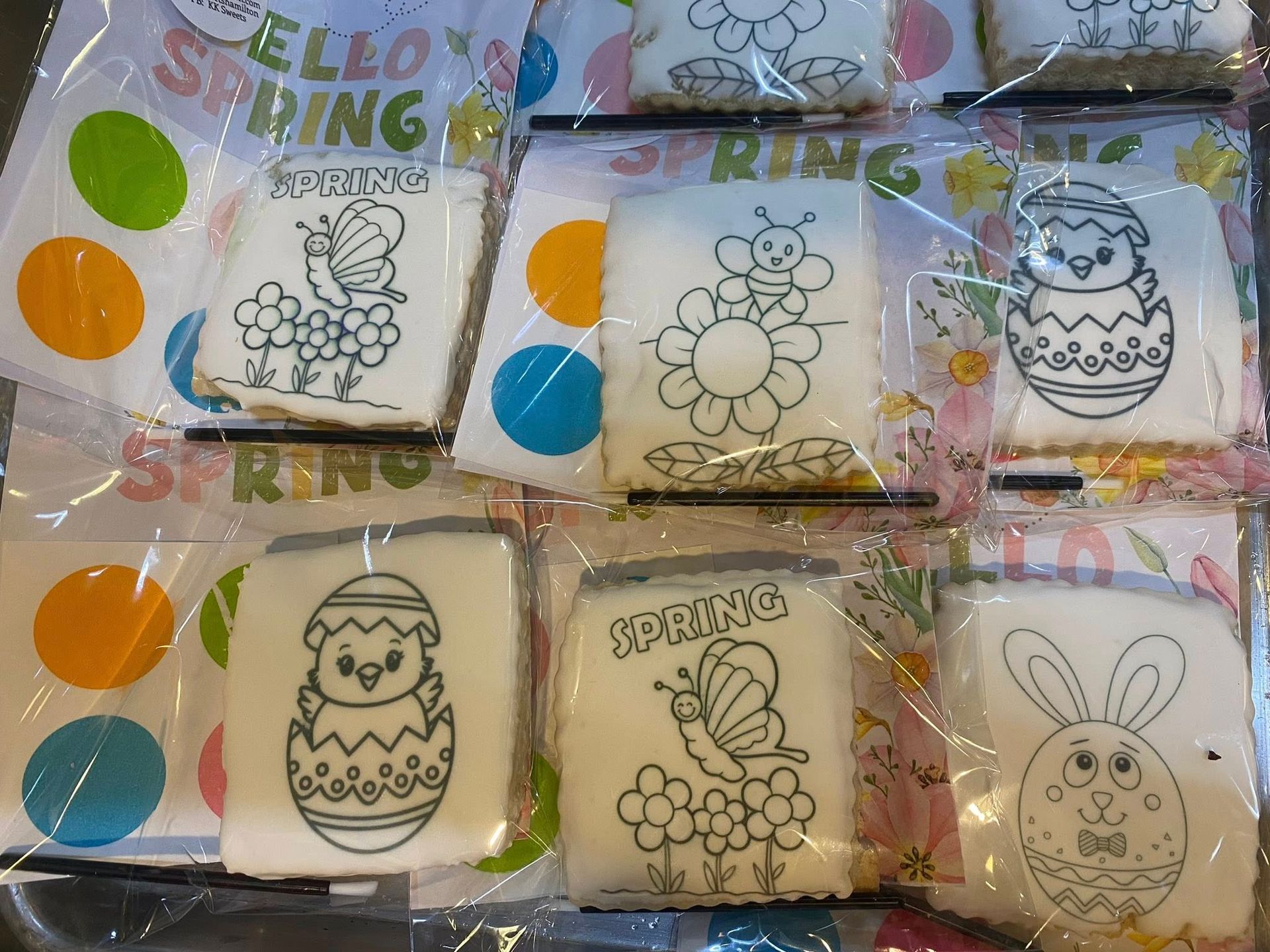 Easter-themed coloring cookies in plastic wrap. Decorated with spring characters and packaged with colorful polka-dot paper.