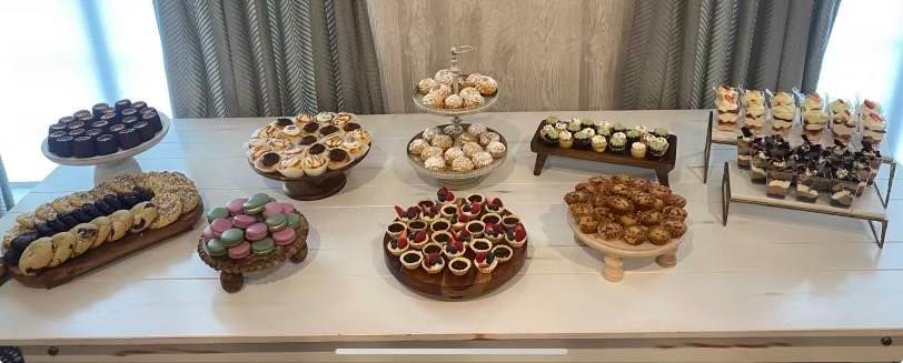 A table displaying a variety of desserts, including cakes, pastries, and candies.