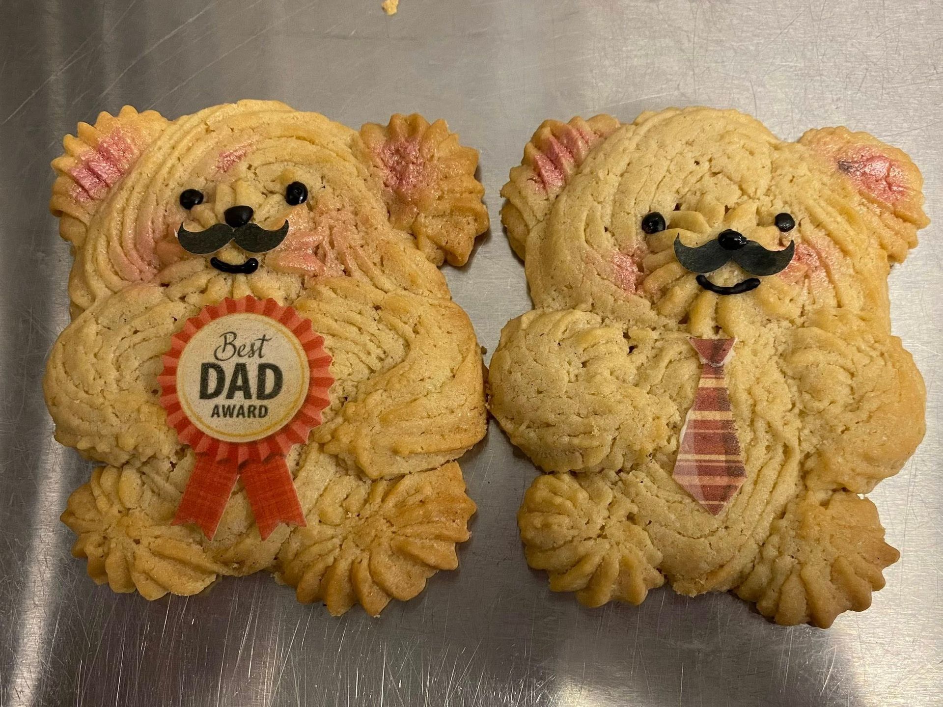 Two bear-shaped cookies with mustaches, one with a 
