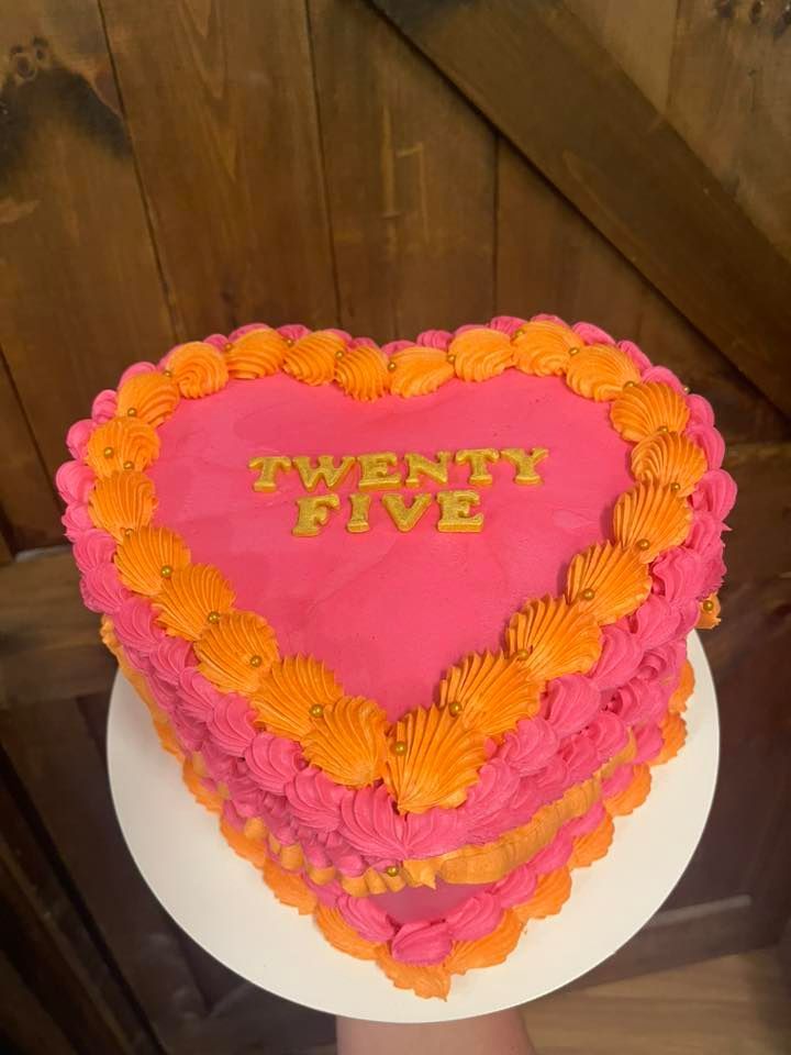 Heart-shaped cake with pink and orange frosting, 