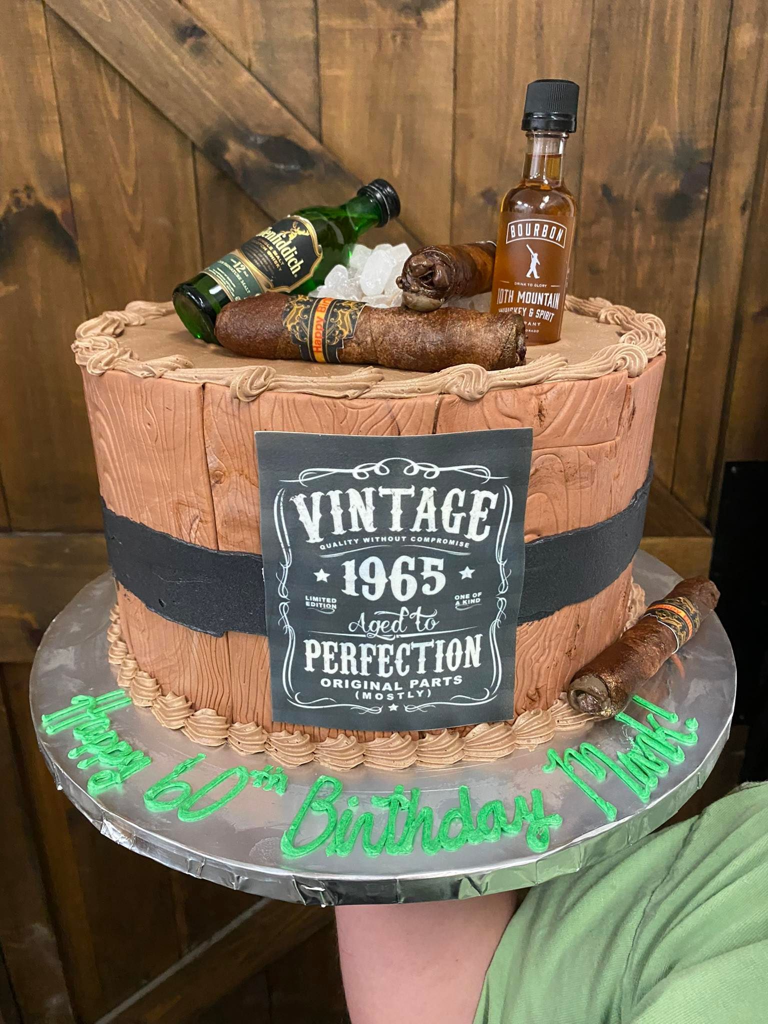 Cake decorated with cigars, bottles, and a 