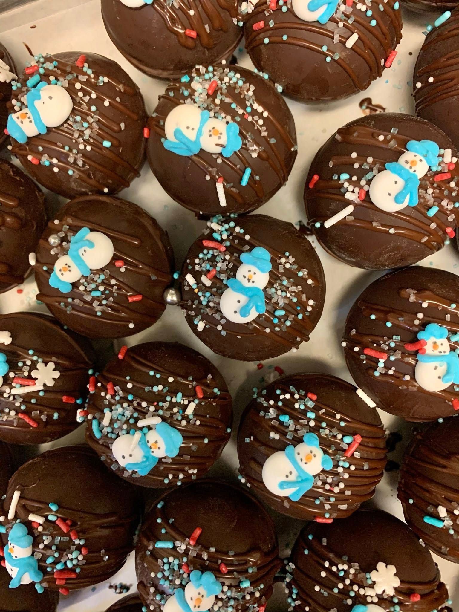 Chocolate treats decorated with snowman candies and sprinkles.