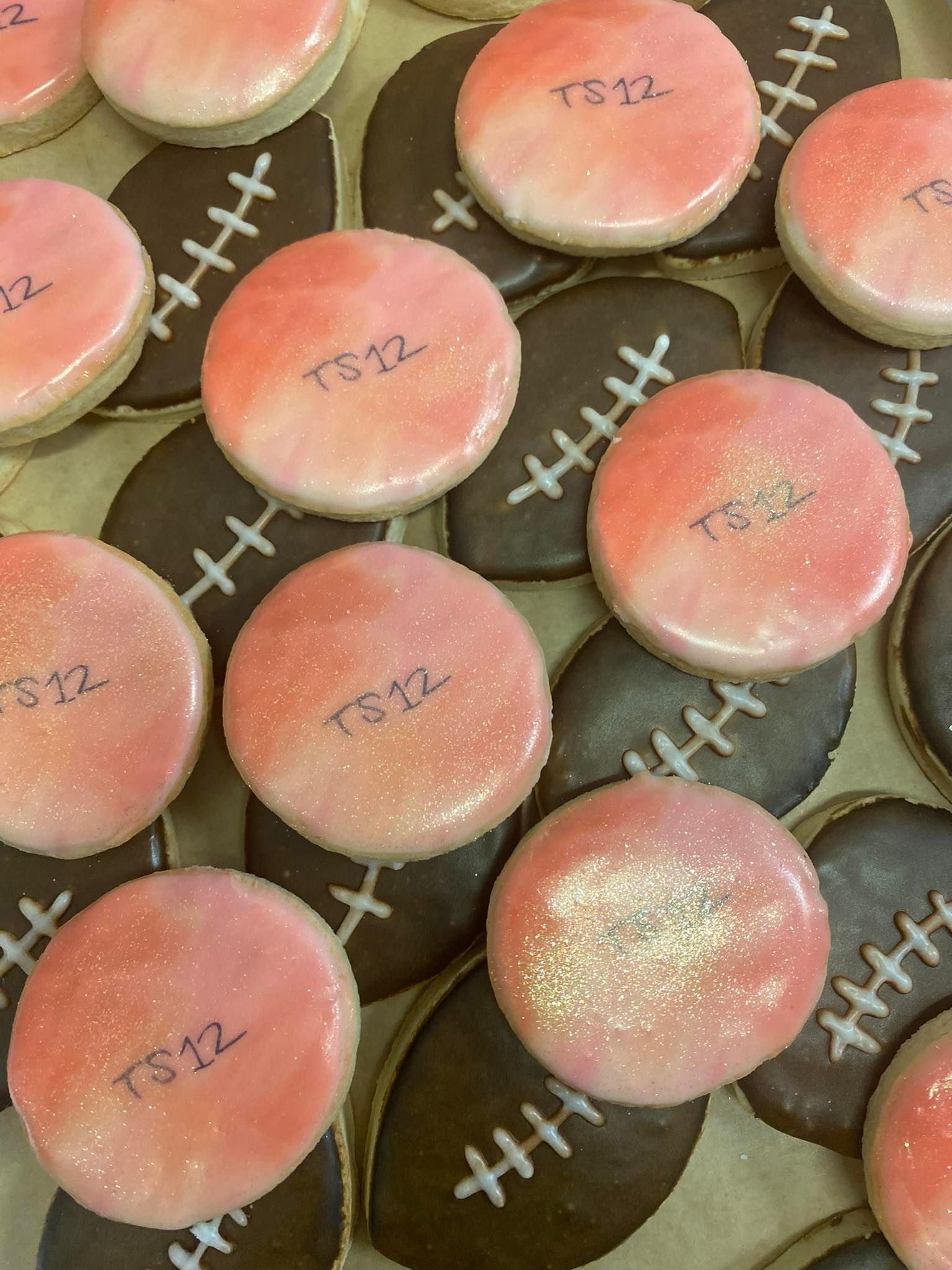 Cookies decorated as footballs and pink circles with 