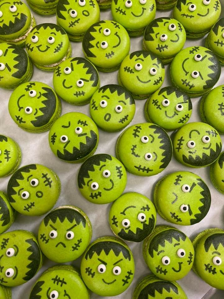 Green Frankenstein macarons with black detailing and various expressions.