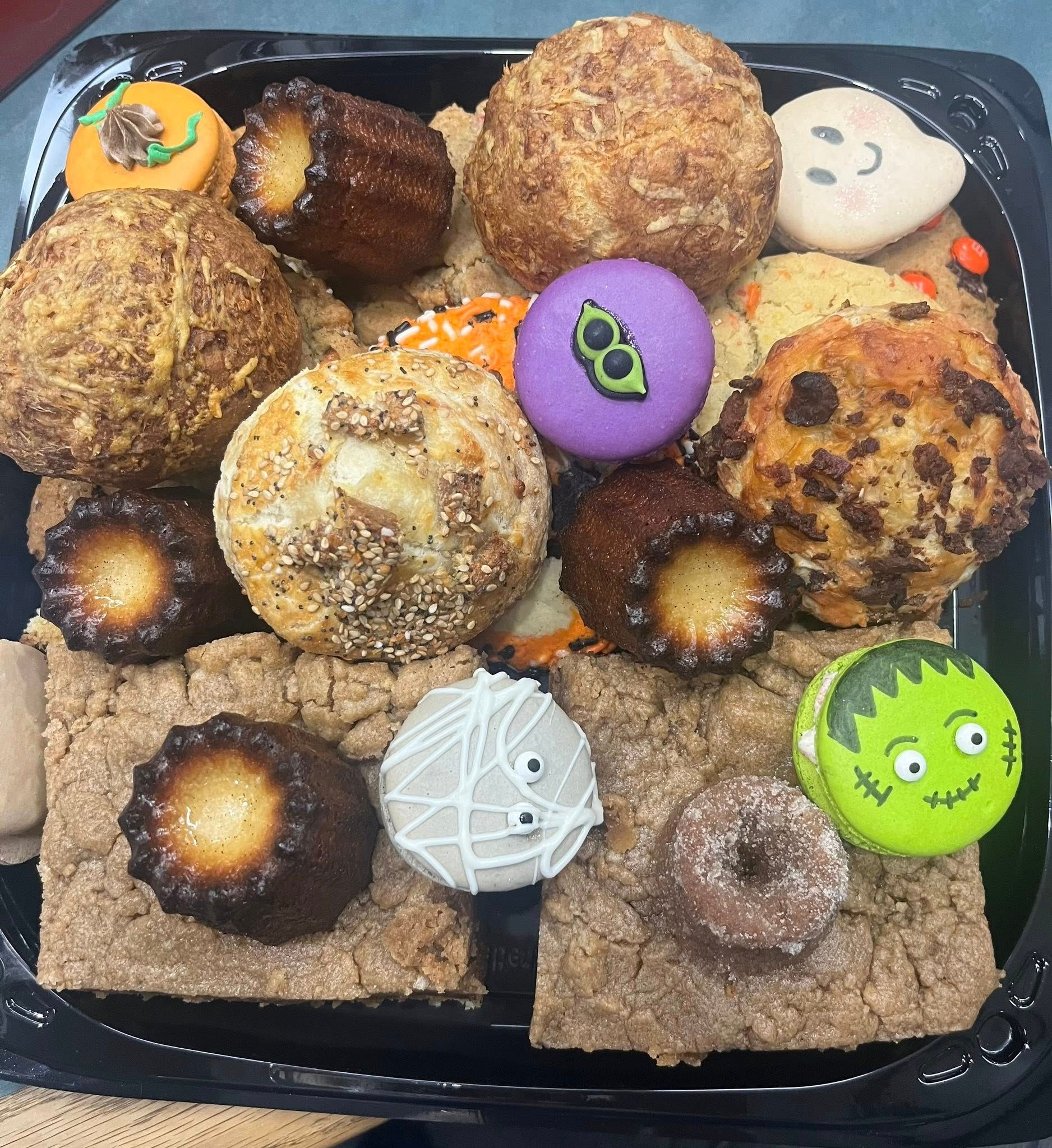 Halloween dessert platter with decorated cookies, cakes, and brownies.