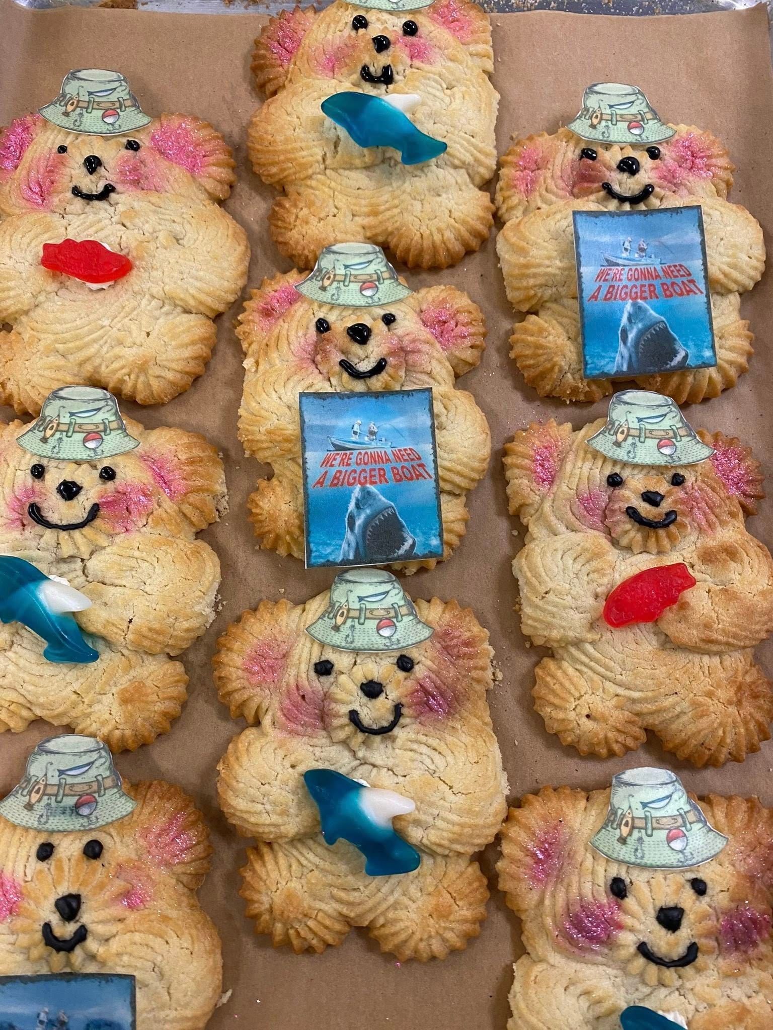 Bear-shaped cookies decorated with fishing hats, holding fish-shaped candies, and pictures of sharks.