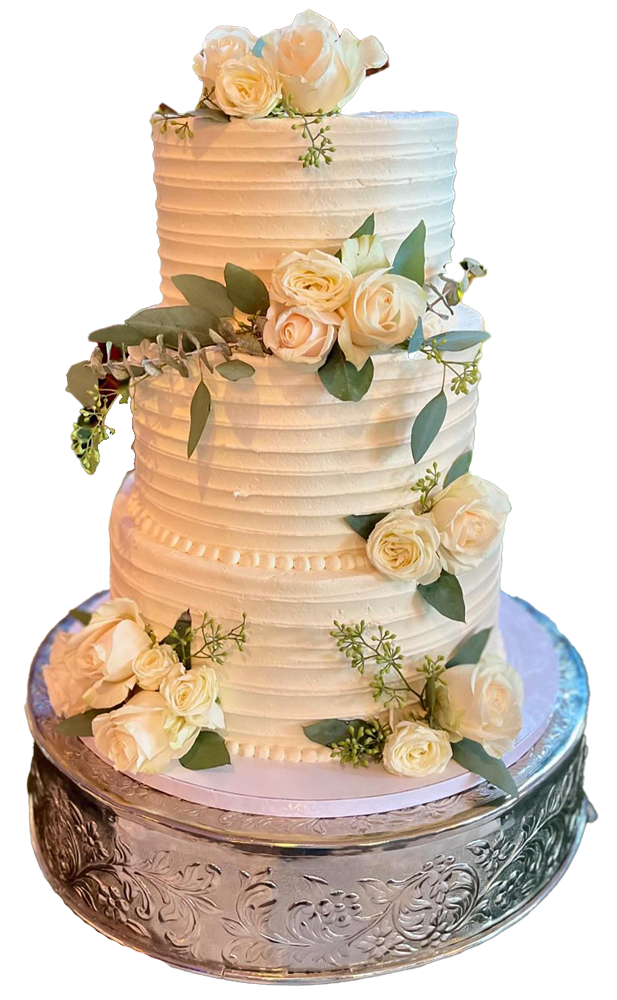 Three-tiered white frosted cake, decorated with roses and greenery, on a silver stand.
