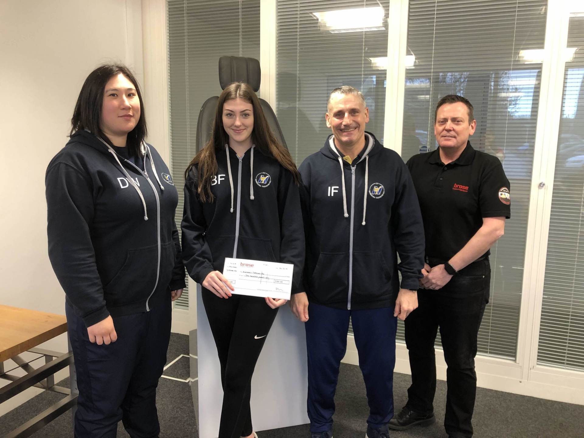 Four adults and large check