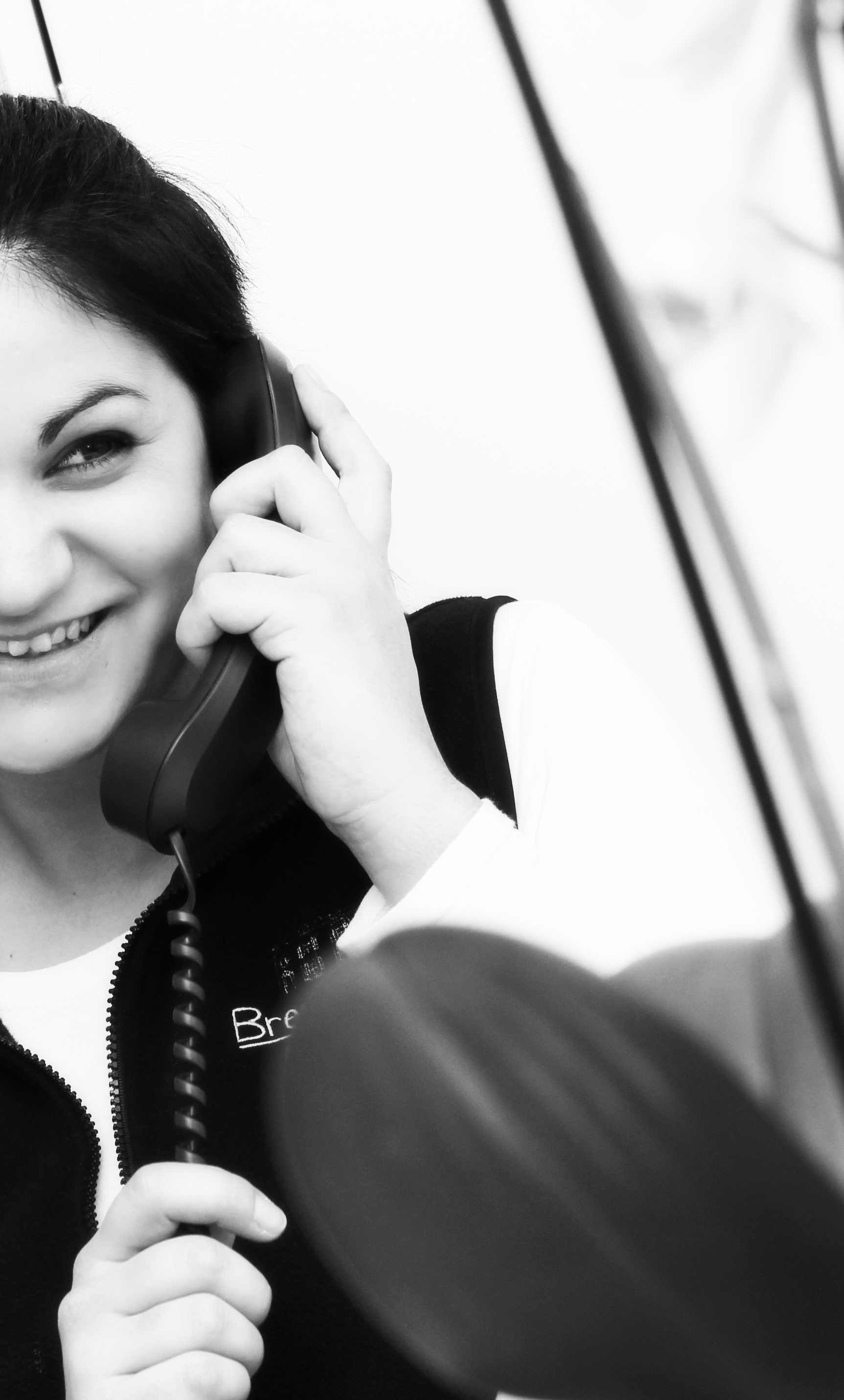 A woman is smiling while talking on a phone
