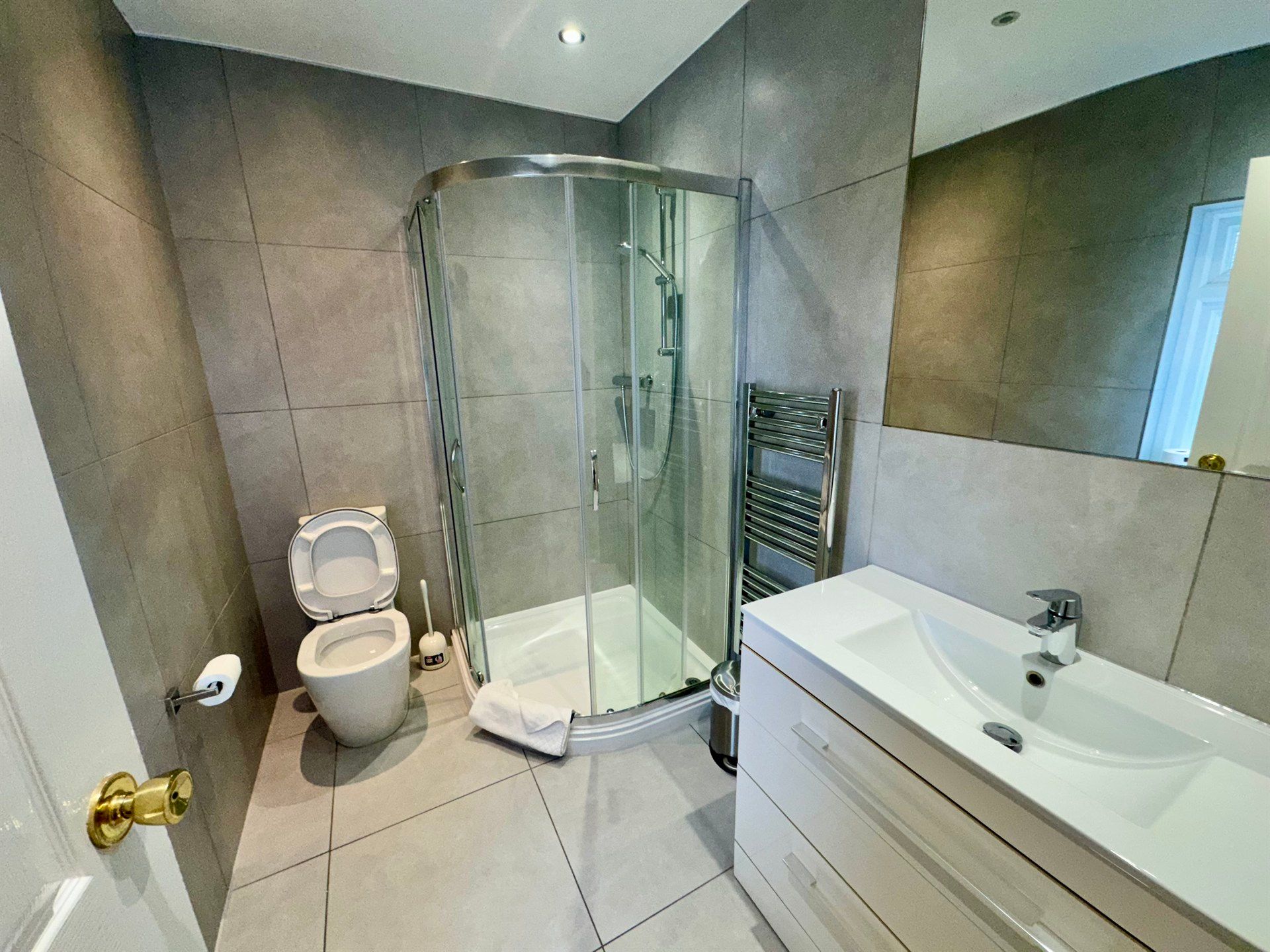 A bathroom with a toilet , sink and shower.