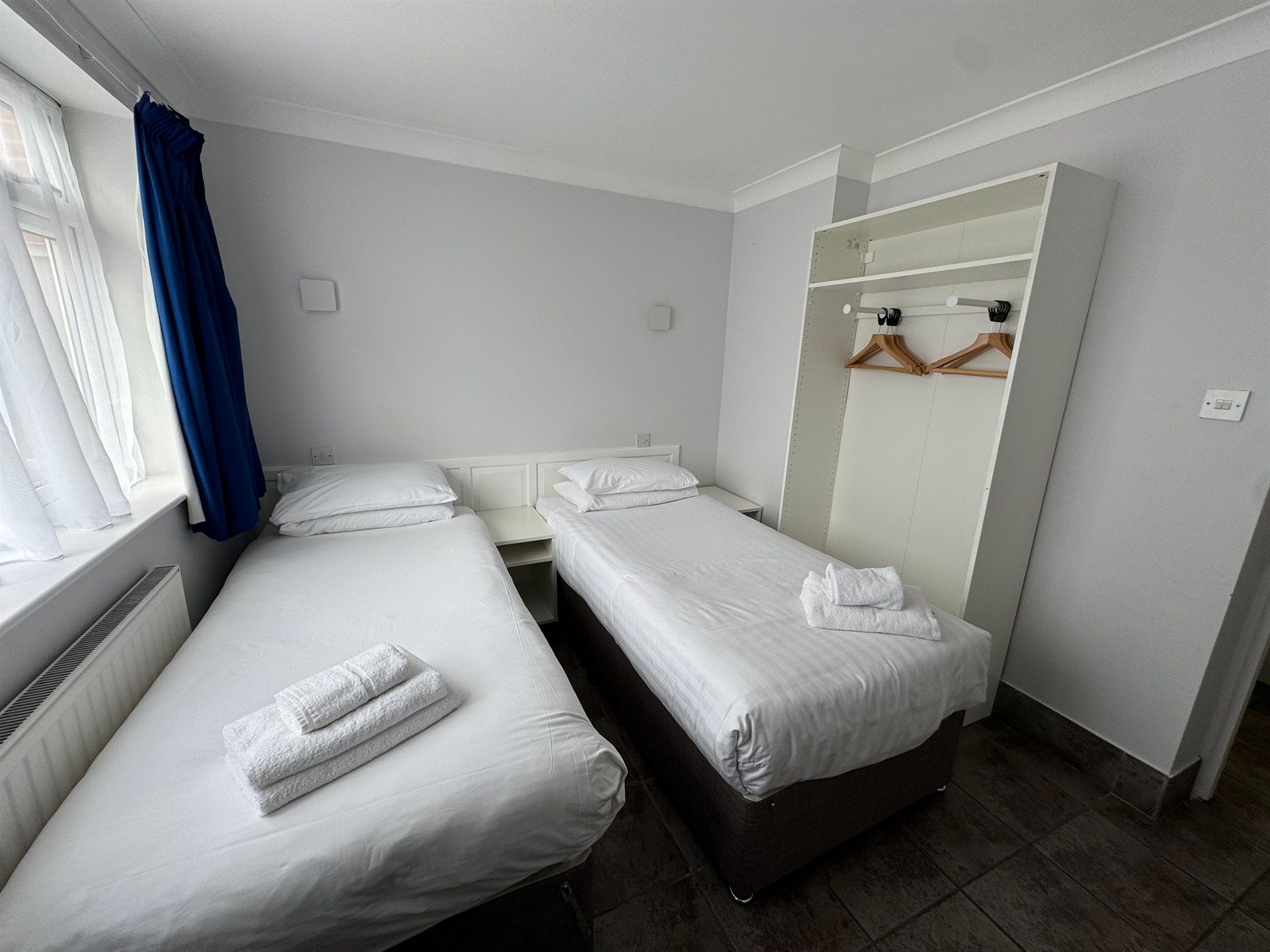 A hotel room with two beds and a closet.