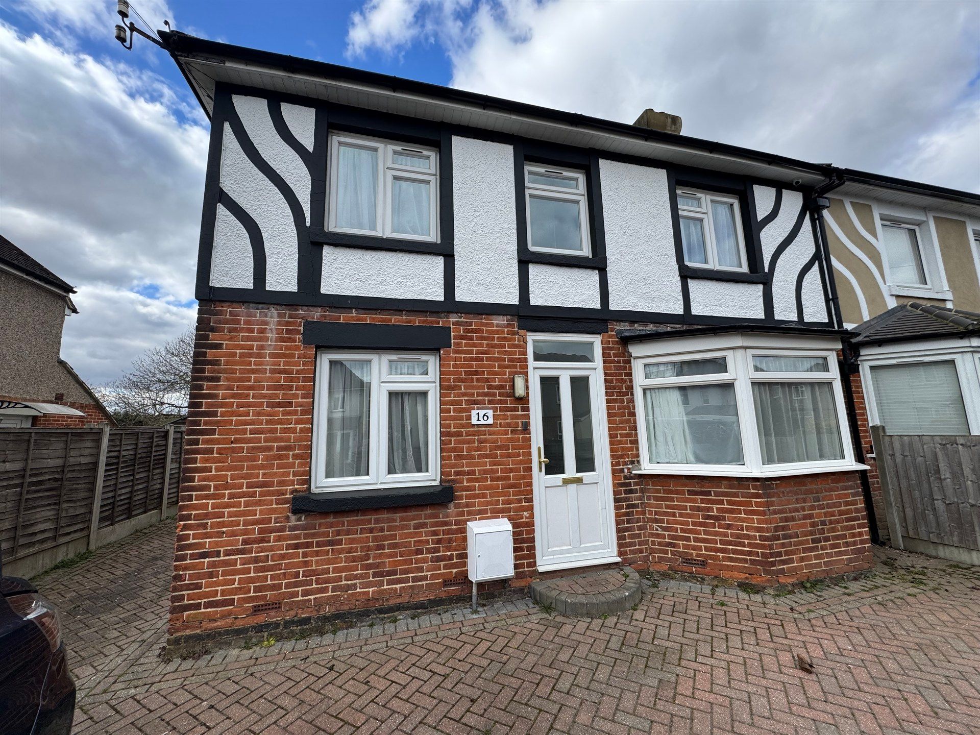 A brick house with a car parked in front of it.