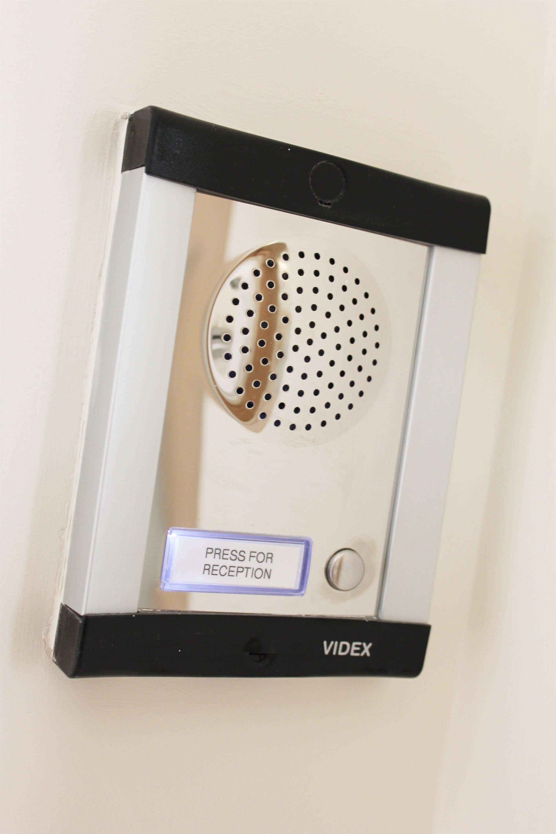 A video door entry system is hanging on a wall.