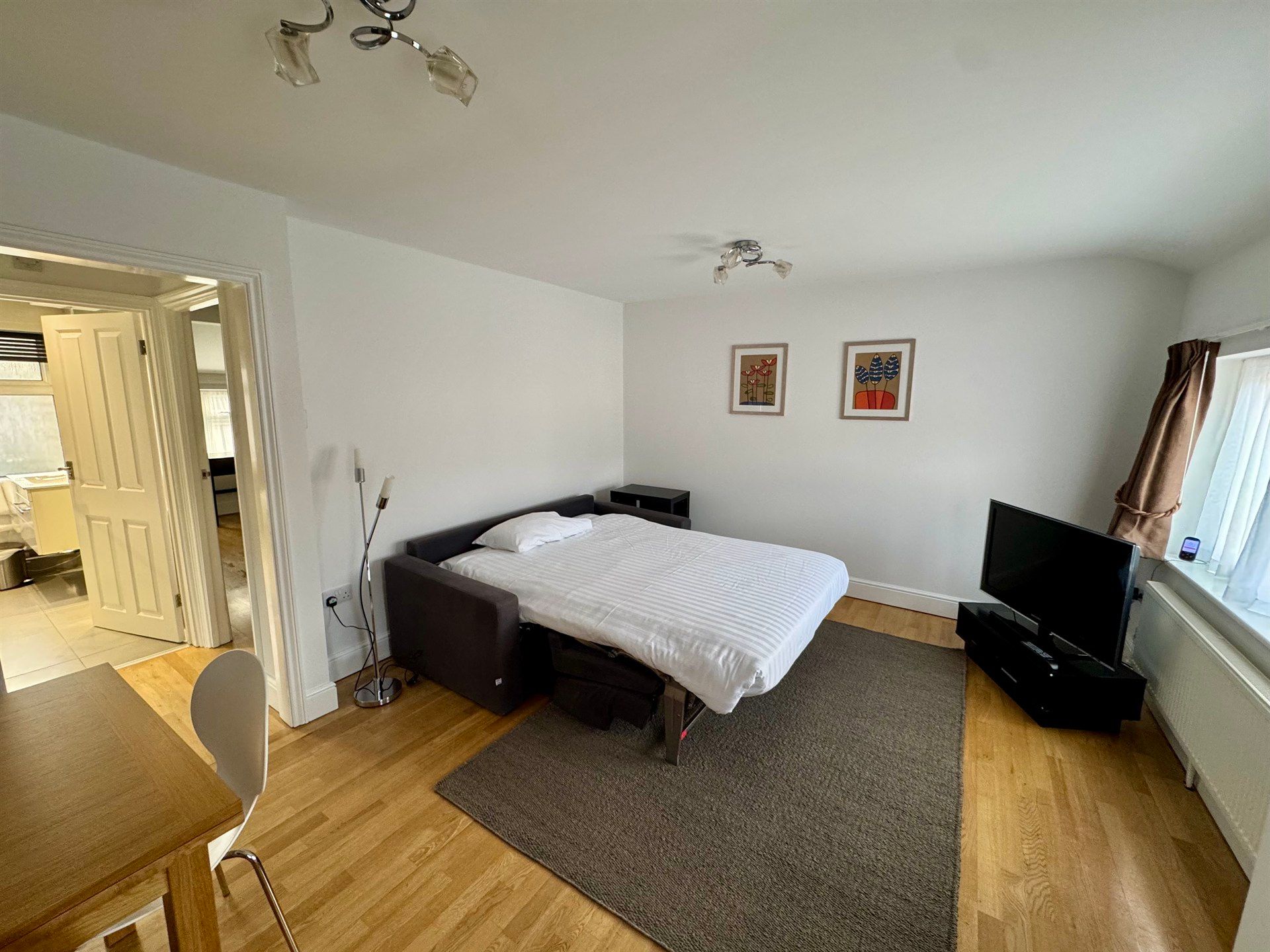 A bedroom with a couch that has been converted into a bed.