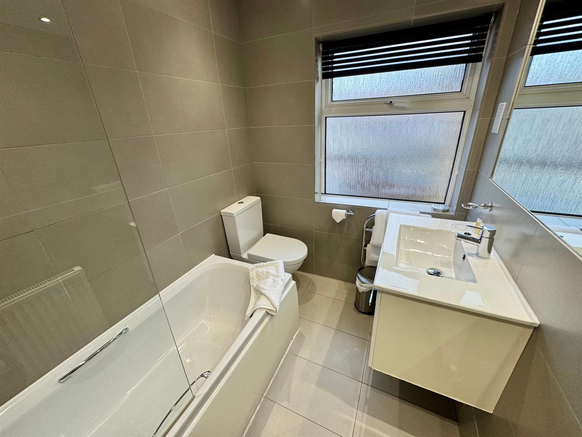 A bathroom with a bathtub , toilet , sink and mirror.