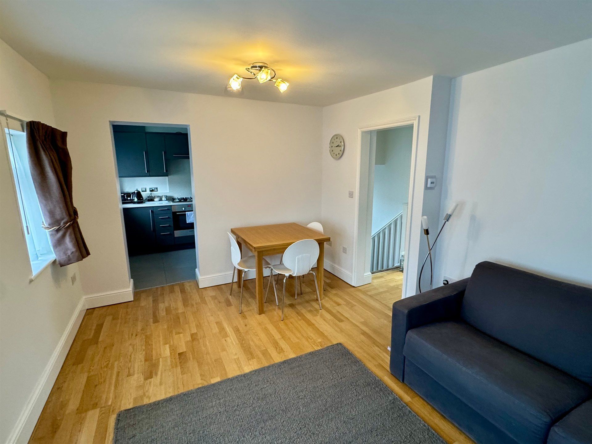 A living room with a couch , table and chairs.